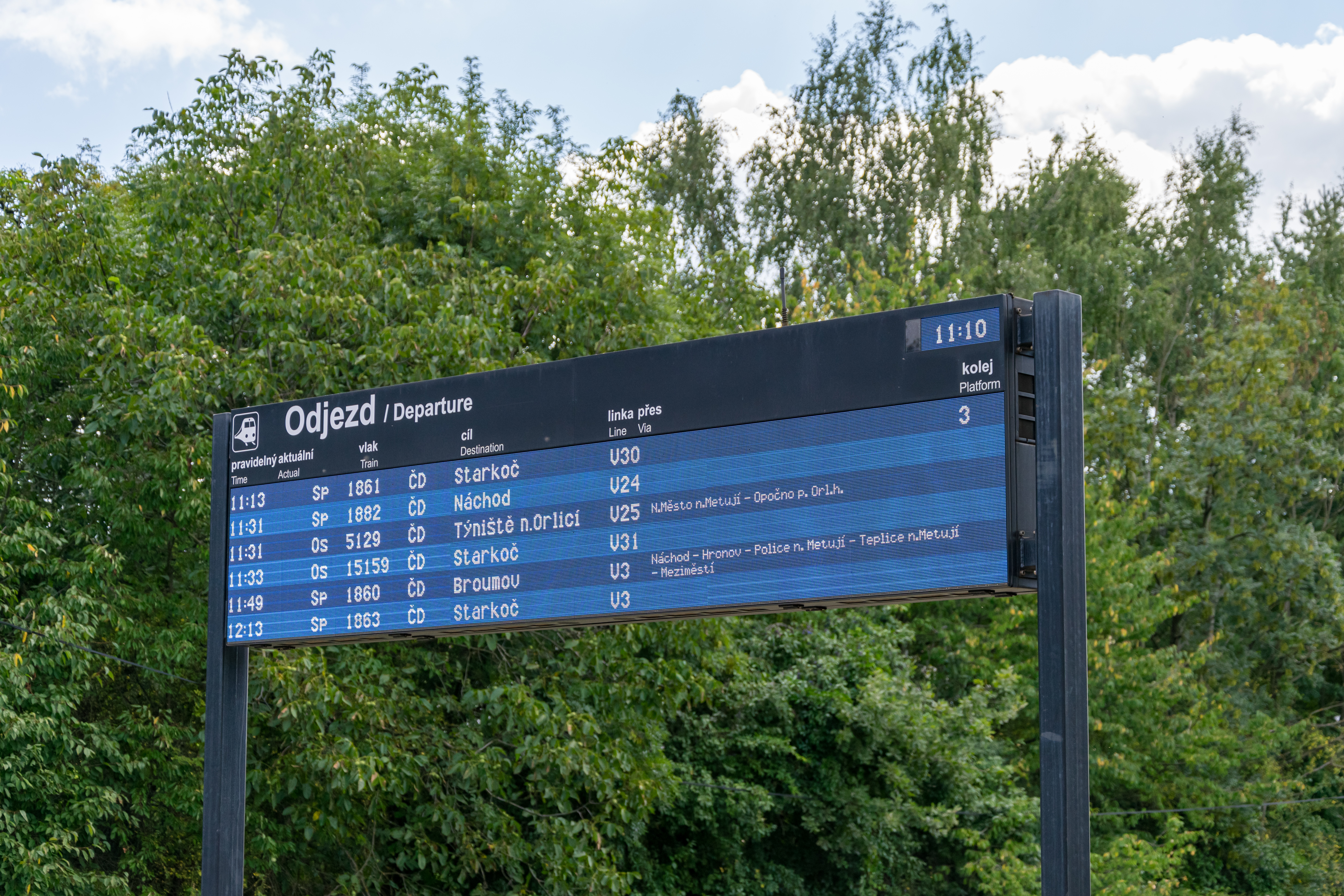 digital departure board on a small Czech station listing upcoming trains to various regional destinations