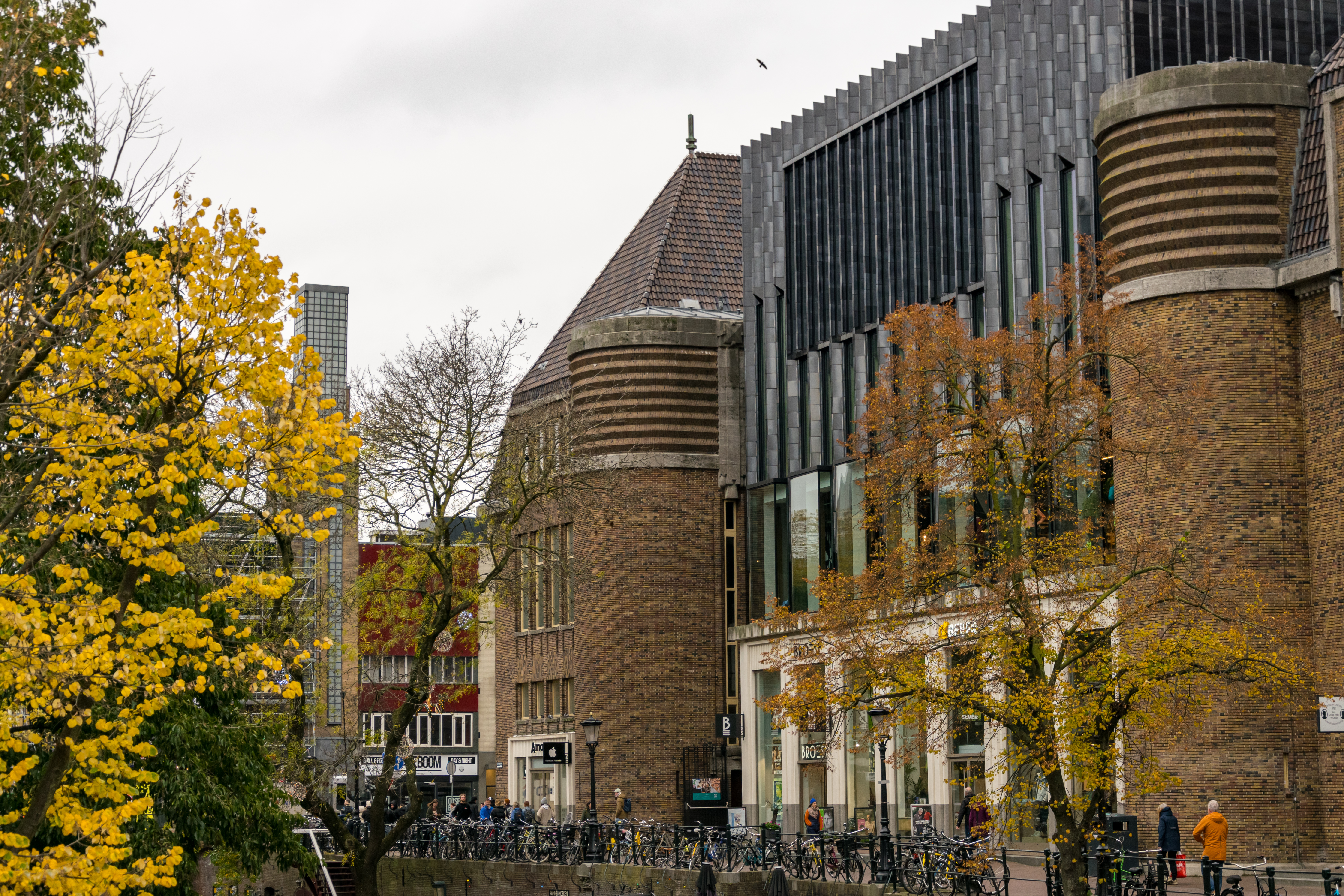 big bulbous brick building (bbbb for short) next to a canal which has a lot of bikes parked on its fence