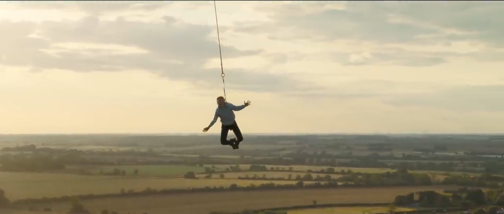 tom scottbeing held in the air high up, by a rope