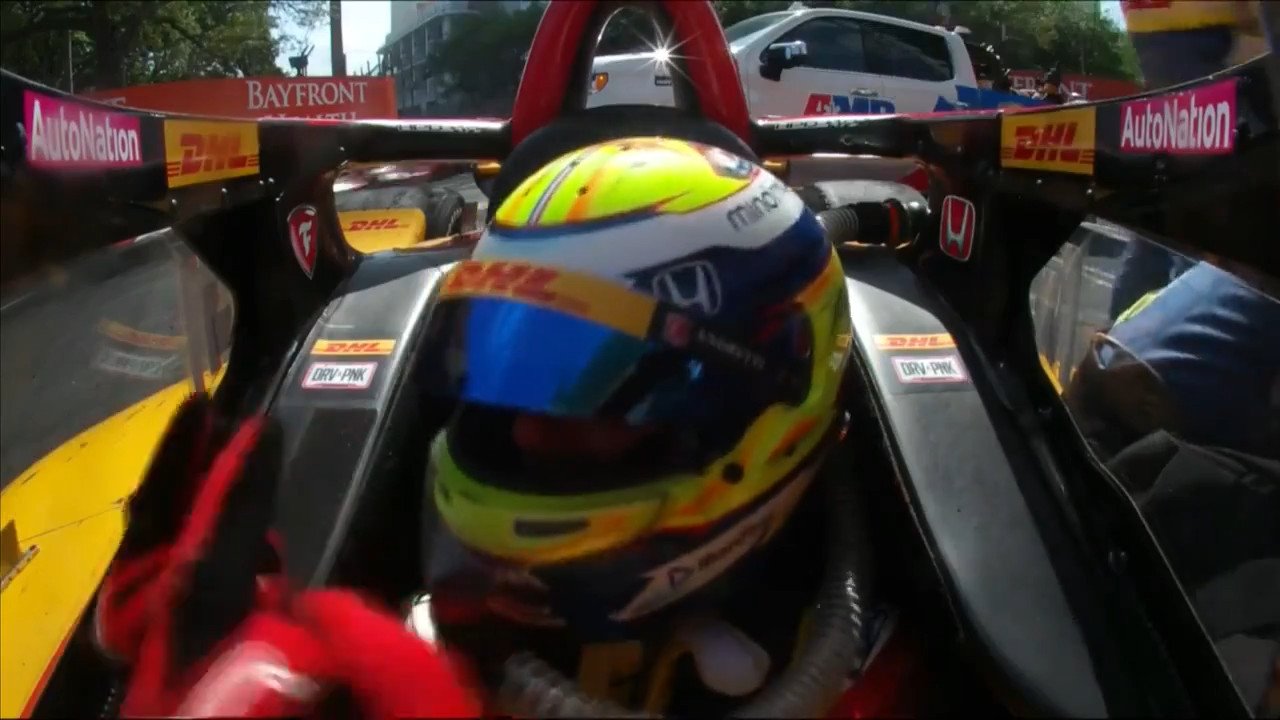 picture of Romain Grosjean in his car while in the wall, looking to the side and showing his 2 middle fingers