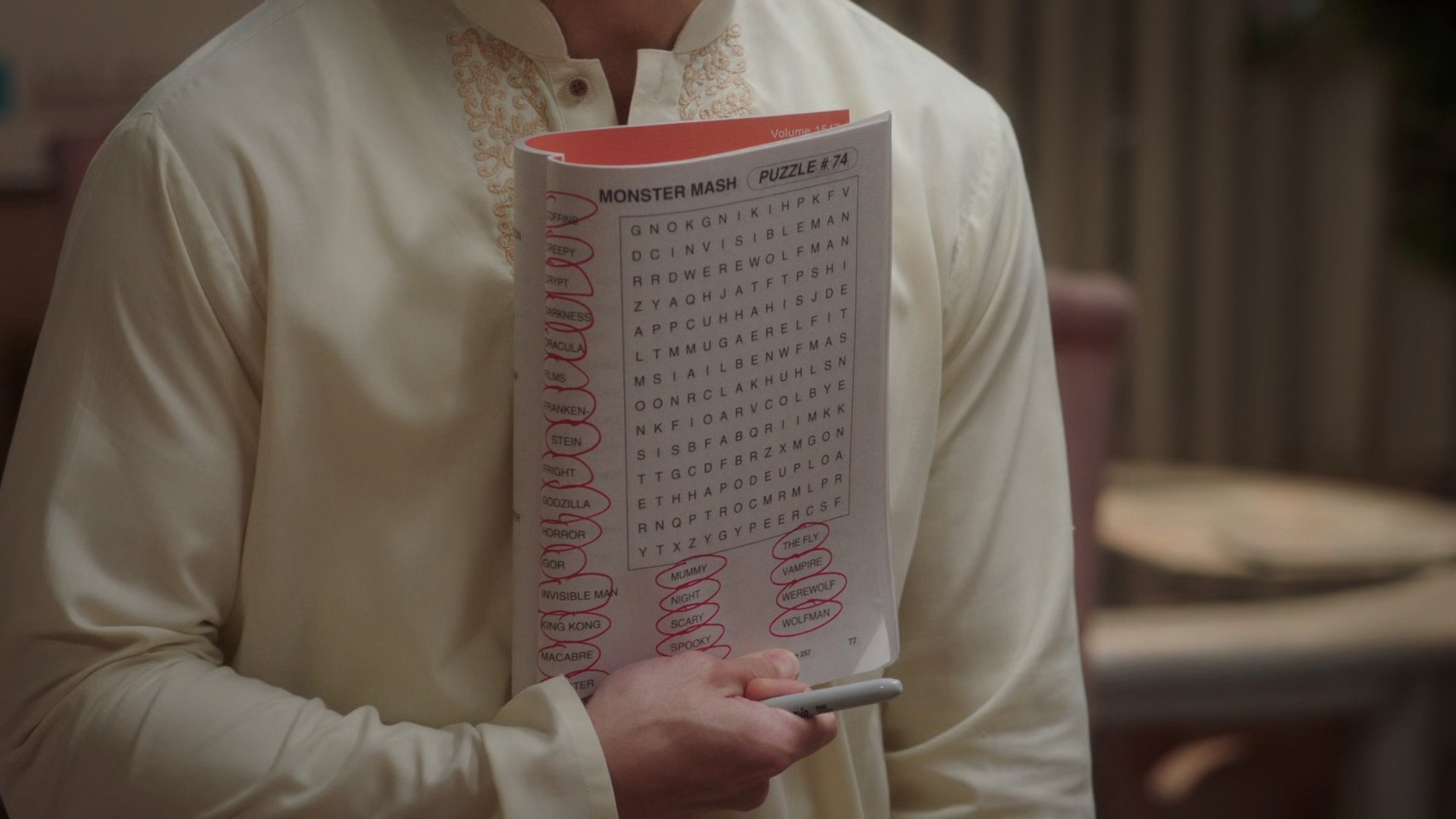jason showing a page in a puzzle magazine where you have to find words in a scramble of letters. he has all the sample words circled, and the sheet itself is empty.