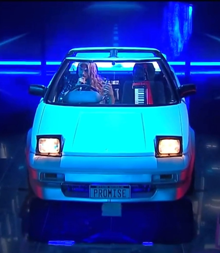 long haired singer (from the band "Voyager") sitting in a Toyota MR2