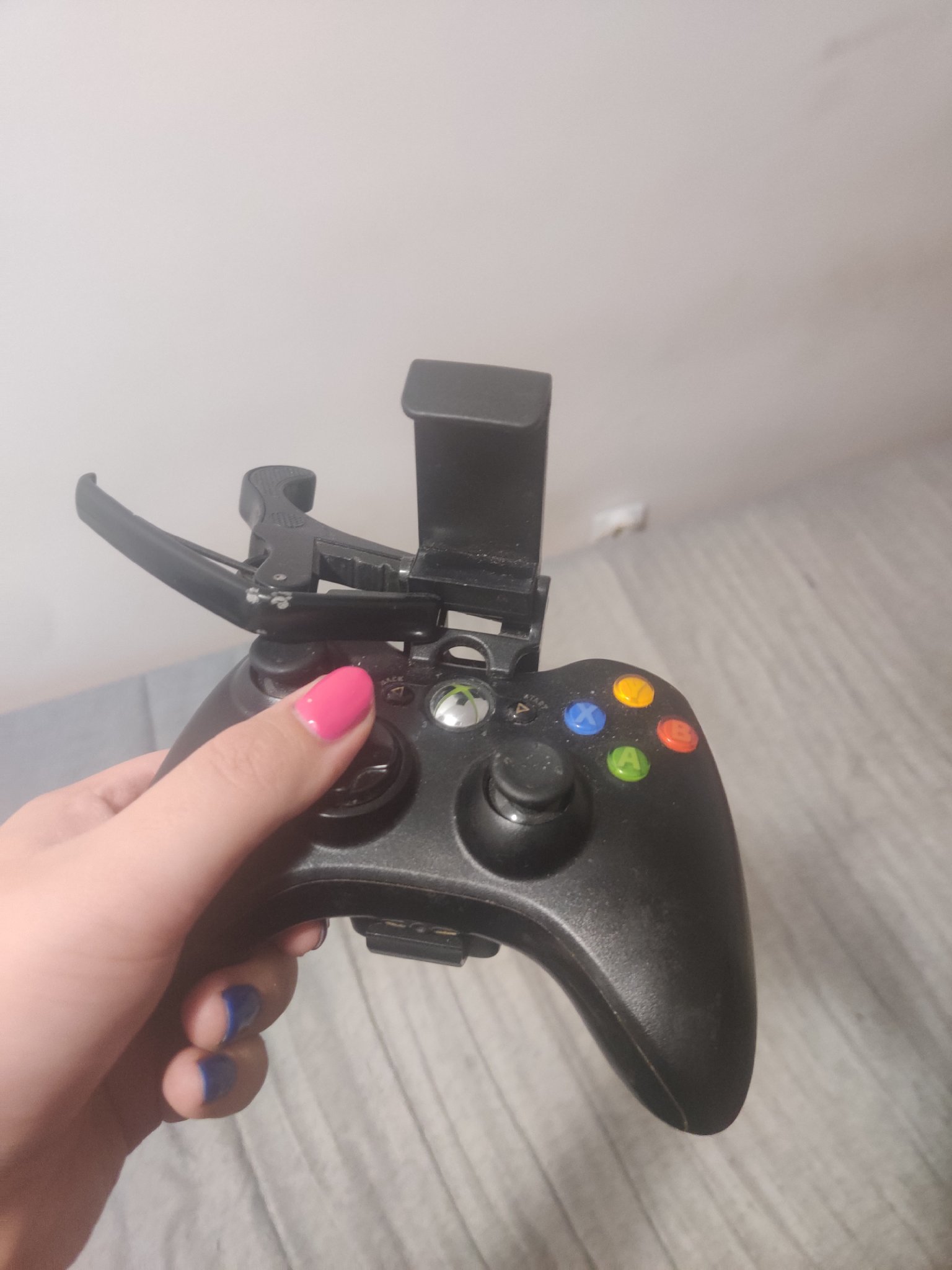 a controller with a phone mount on it. the phone mount has a capo attached to keep it at a specific angle.