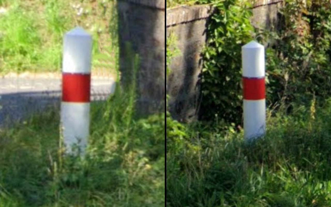 round bollard with a quite big diameter and a pointy top, looks also like a heavy material, it's mostly white, has a full red circle on it
