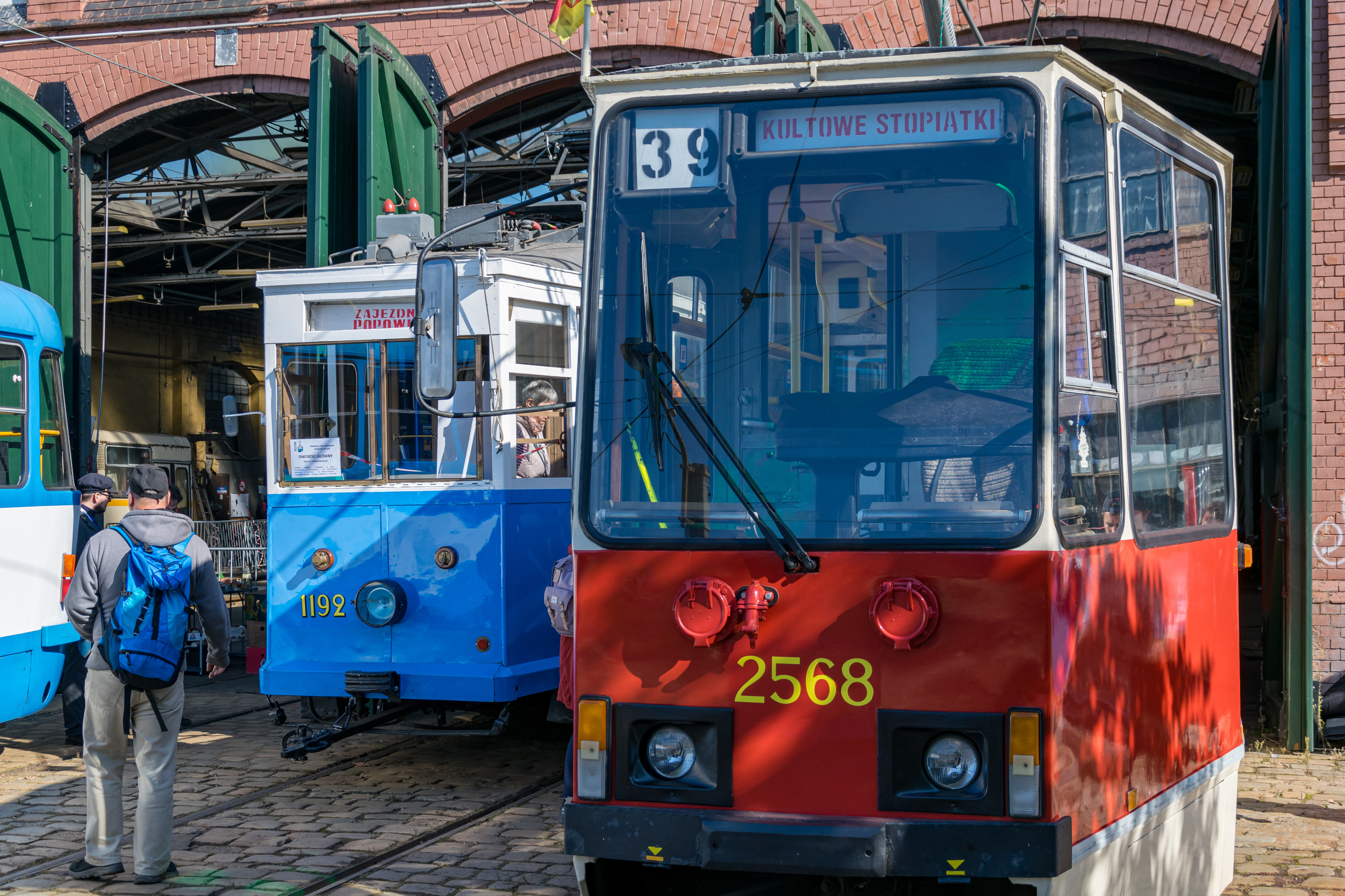 Two trams, white-blue LH Standard and white-red Konstal 105Na standing