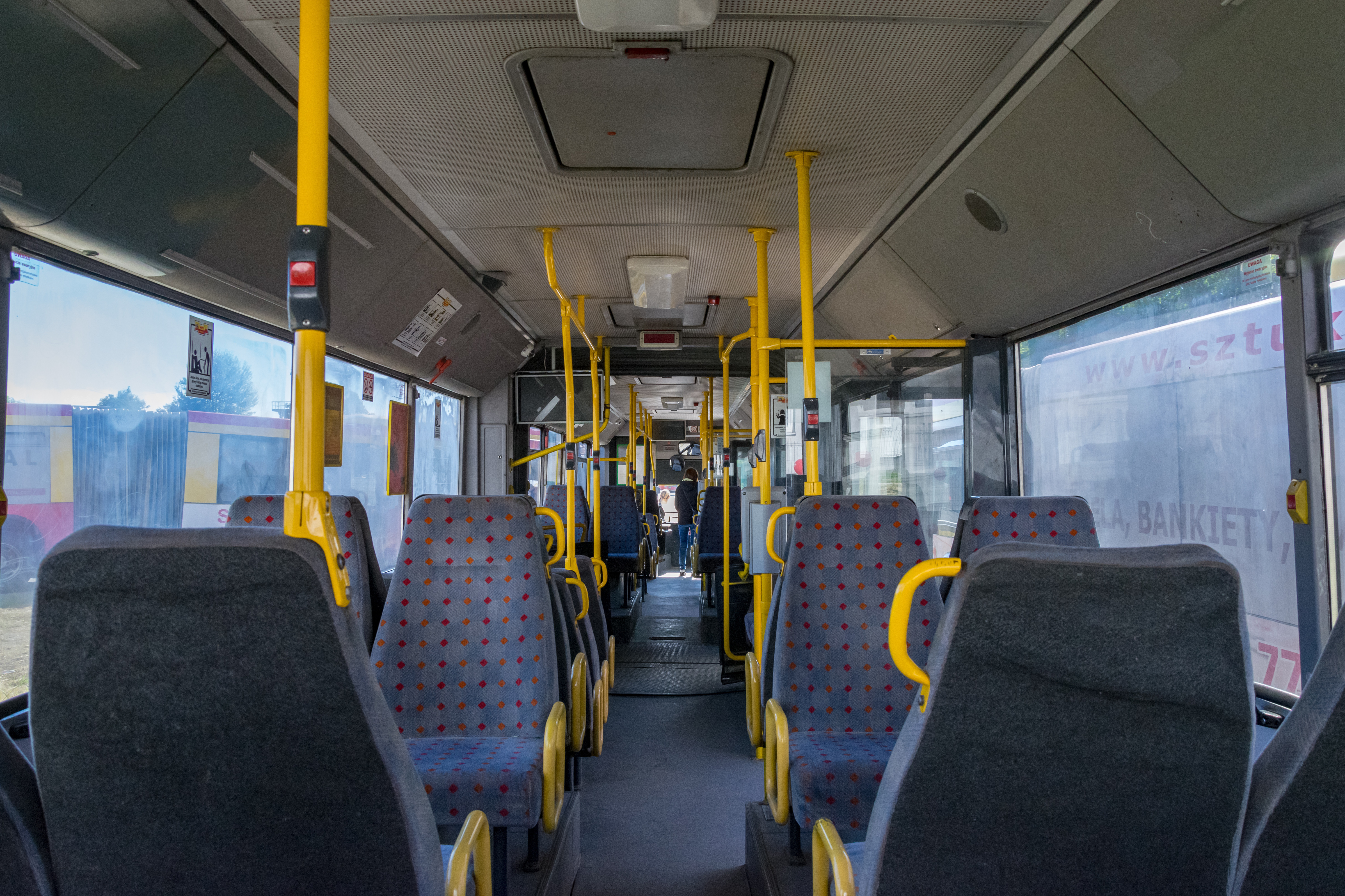 Interior of retiring MAN NG312 articulated bus, it has yellow handlebars and large comfy seats