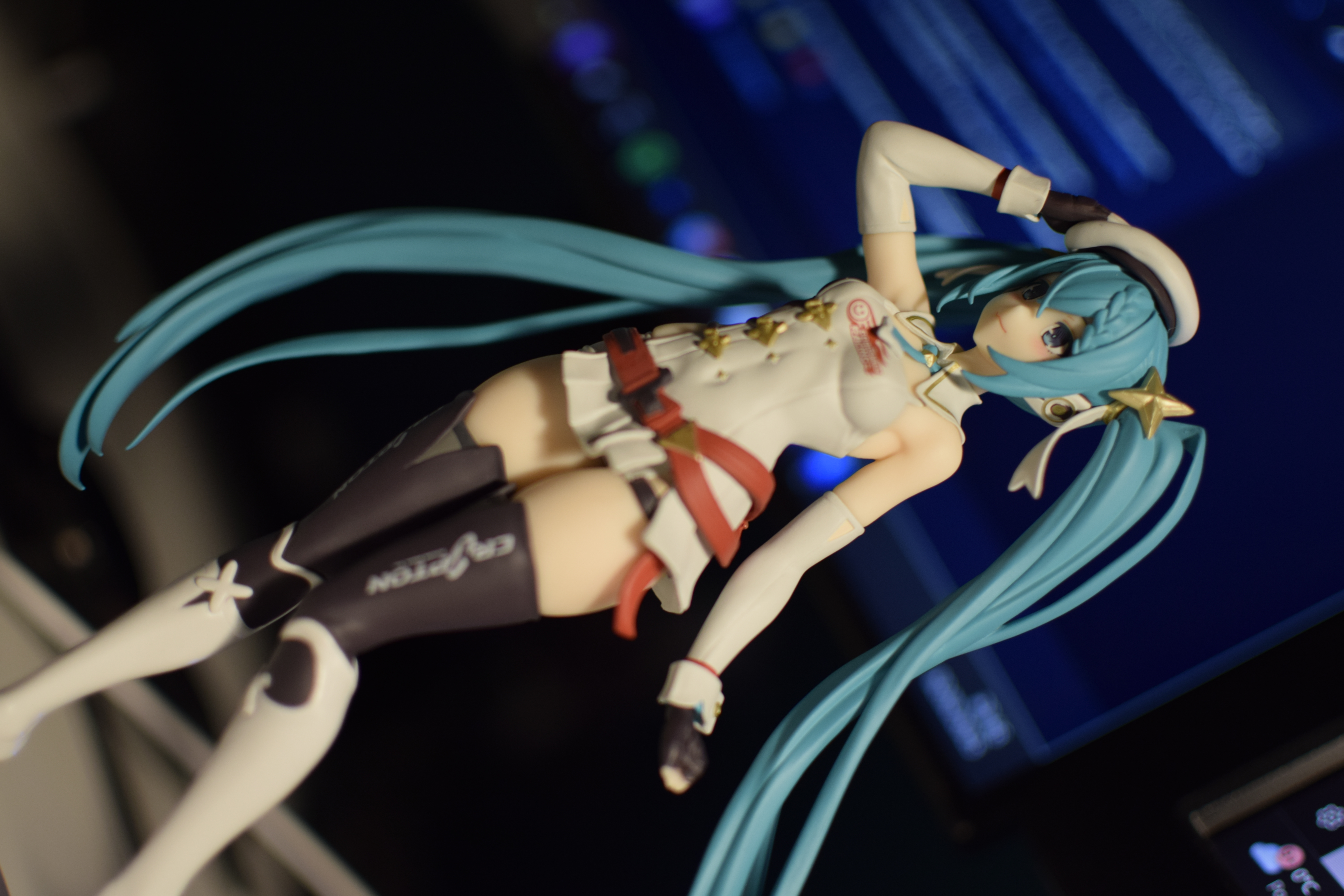 hatsune miku figurine on background of blurred computer displays