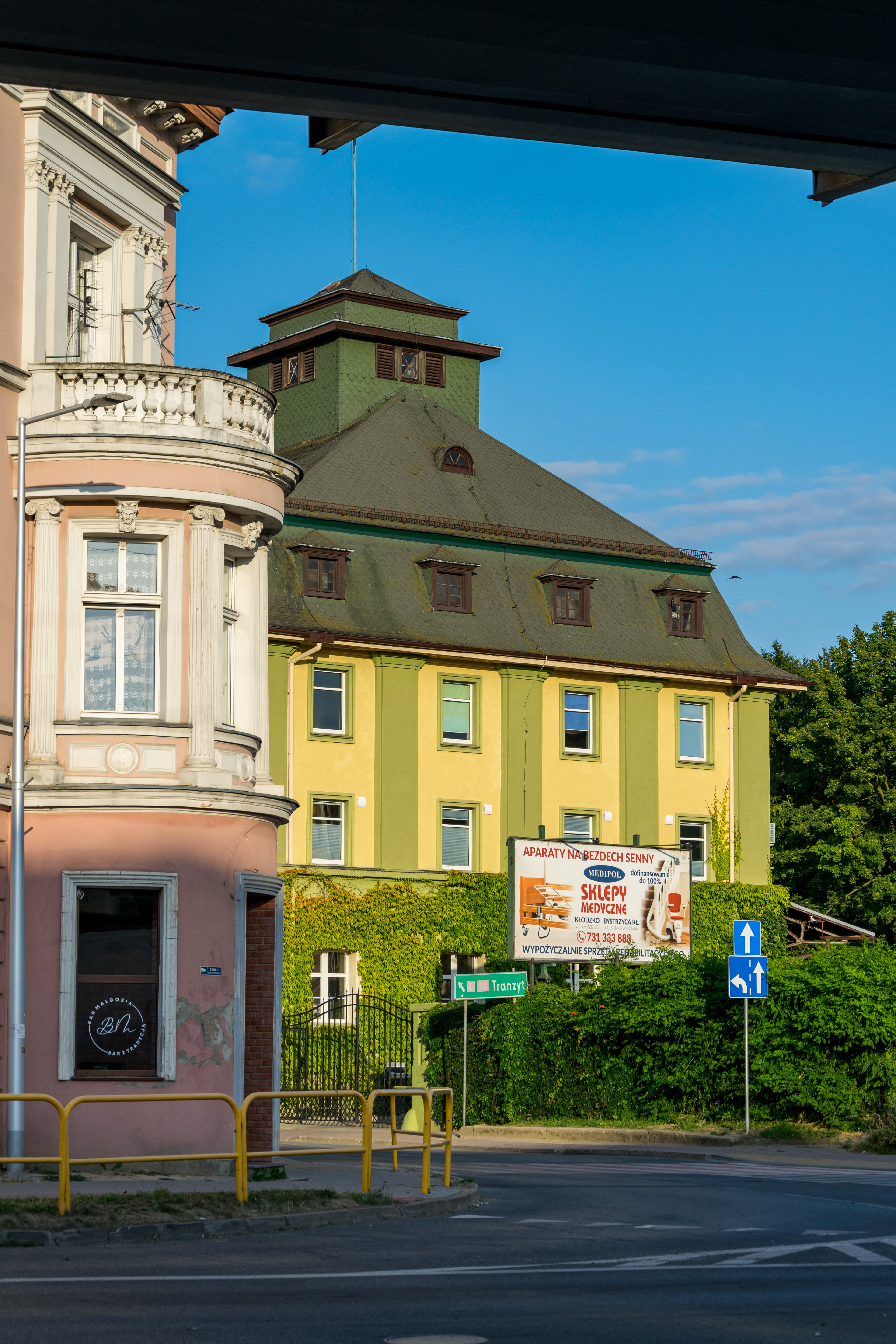 yellow building with lots of greenery around it