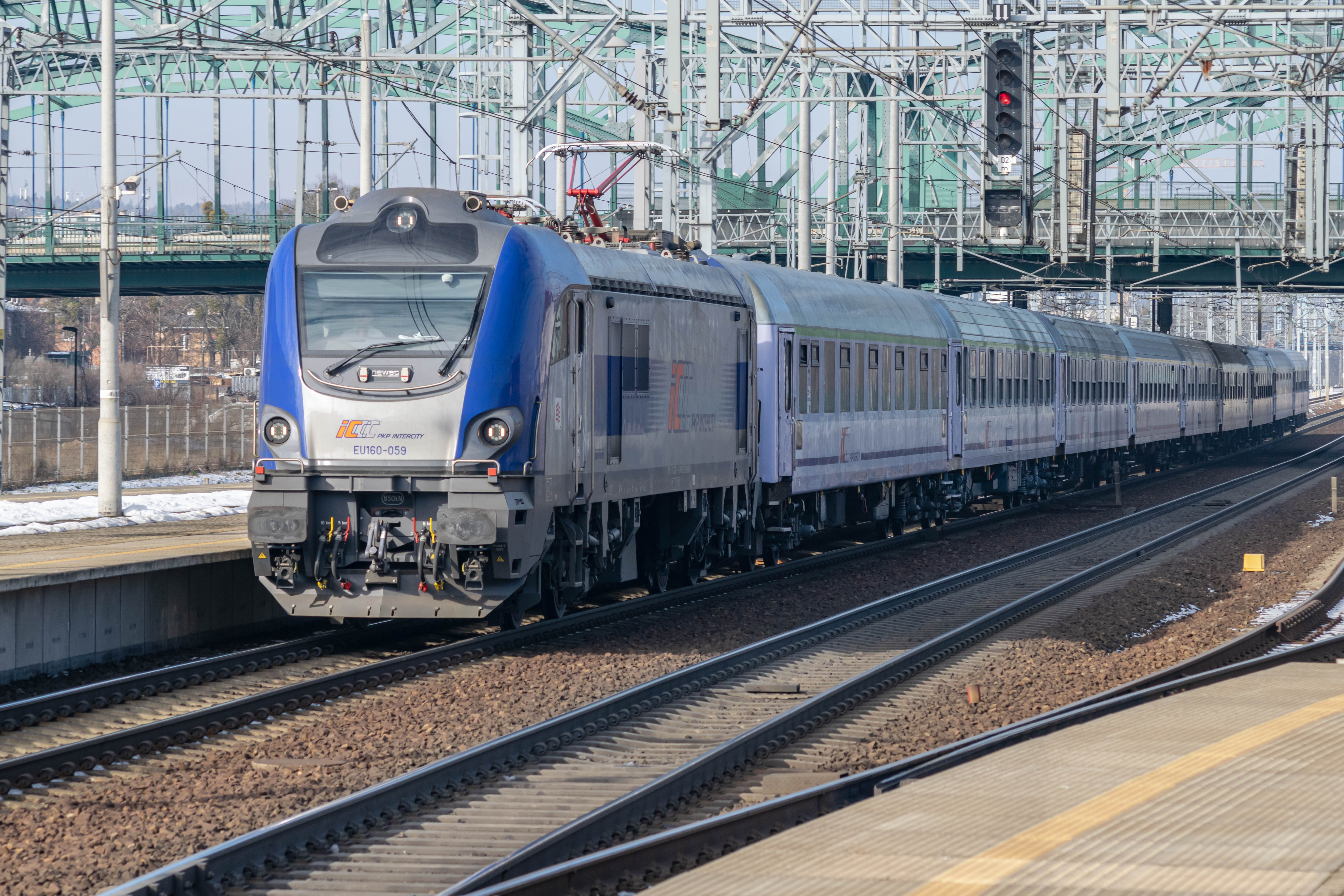 blue-silver locomotive pulling old coaches
