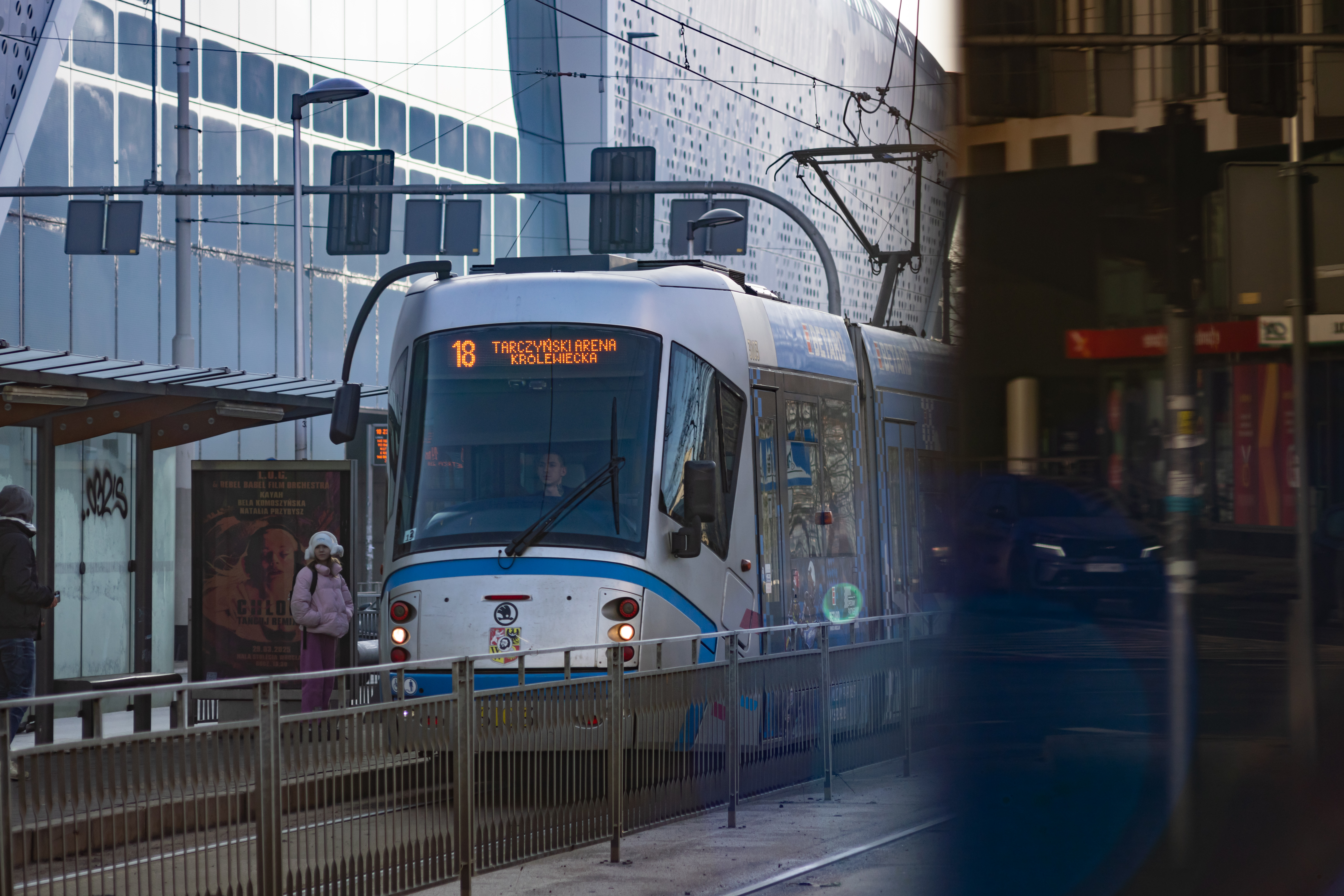silver-blue tram arriving at a tram stop