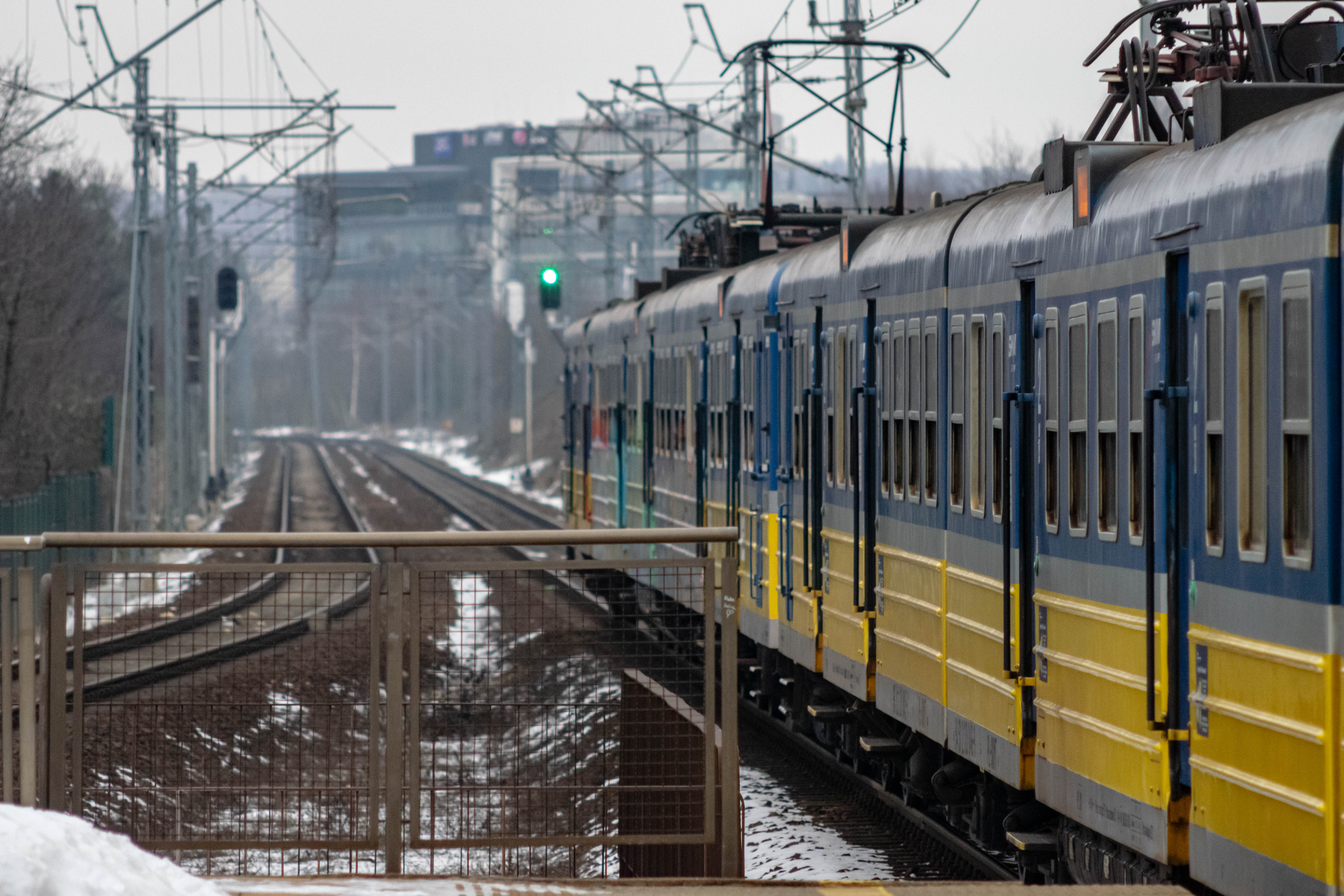 yellow-blue train departing from the station