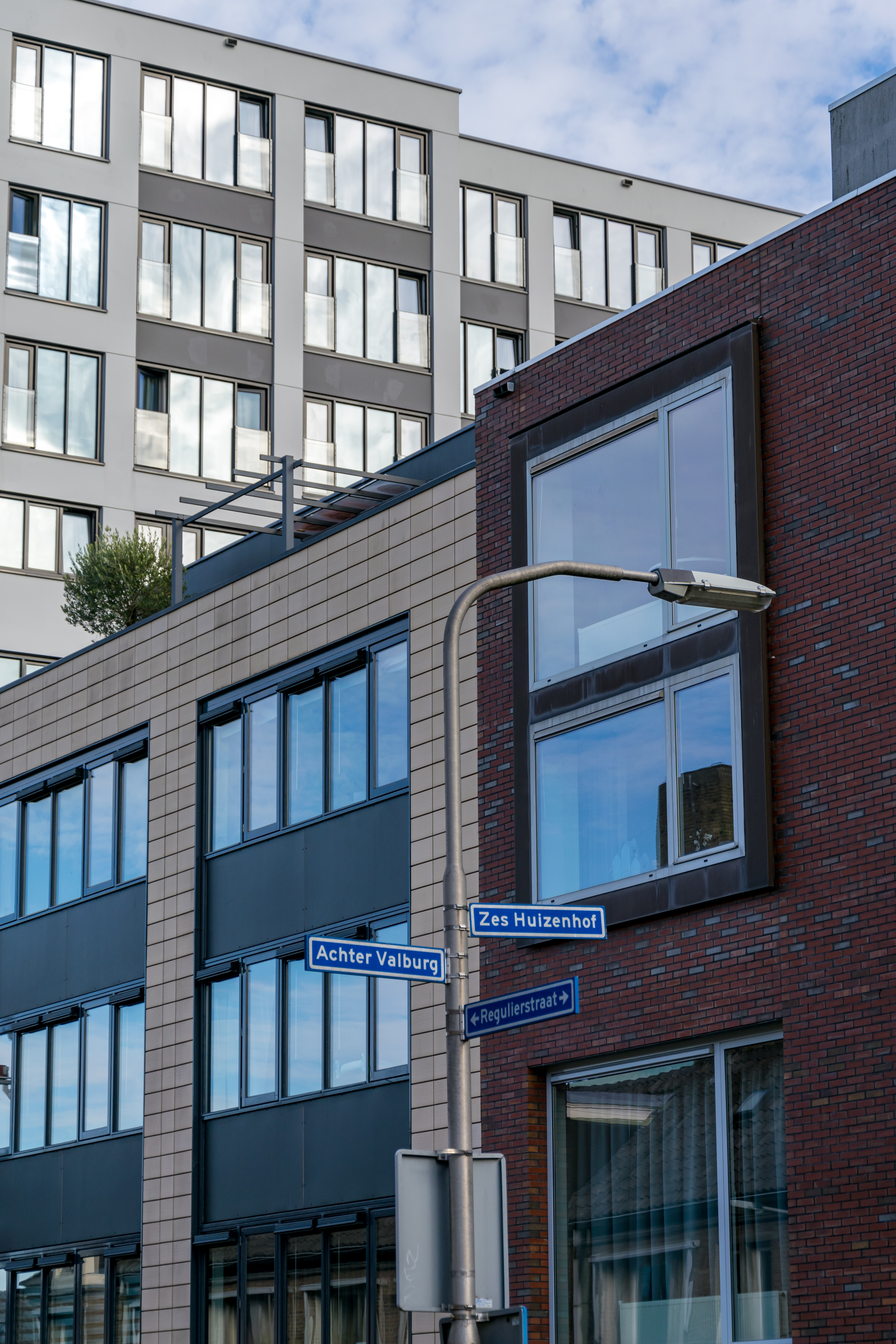 Modern blocks, and a street lamp with street plates on the post