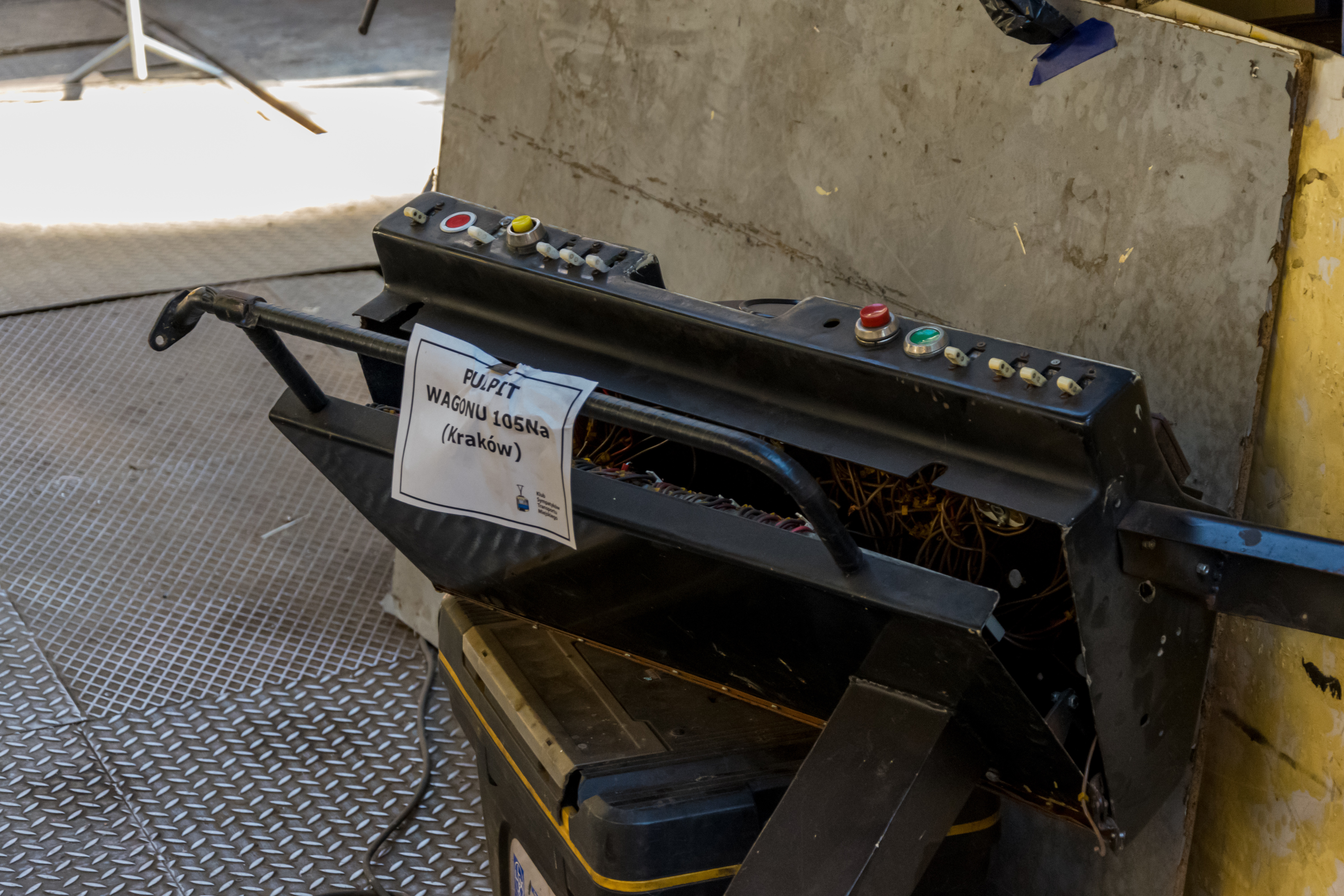 An old, incomplete control panel from Konstal 105Na tram with controls and wires exposed, placed on a container.