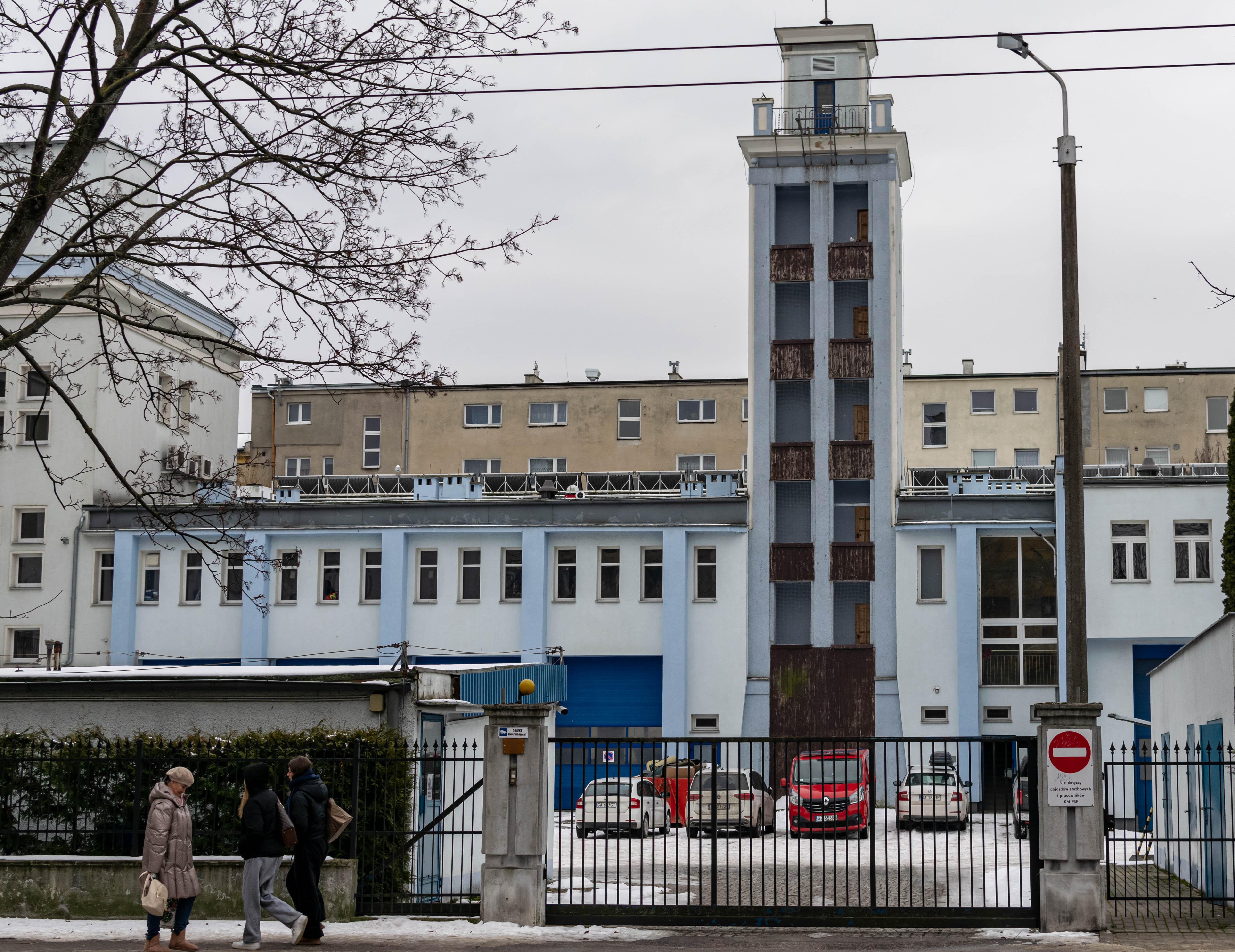 blue-ish building of fire brigade, tower with a bunch of garages visible
