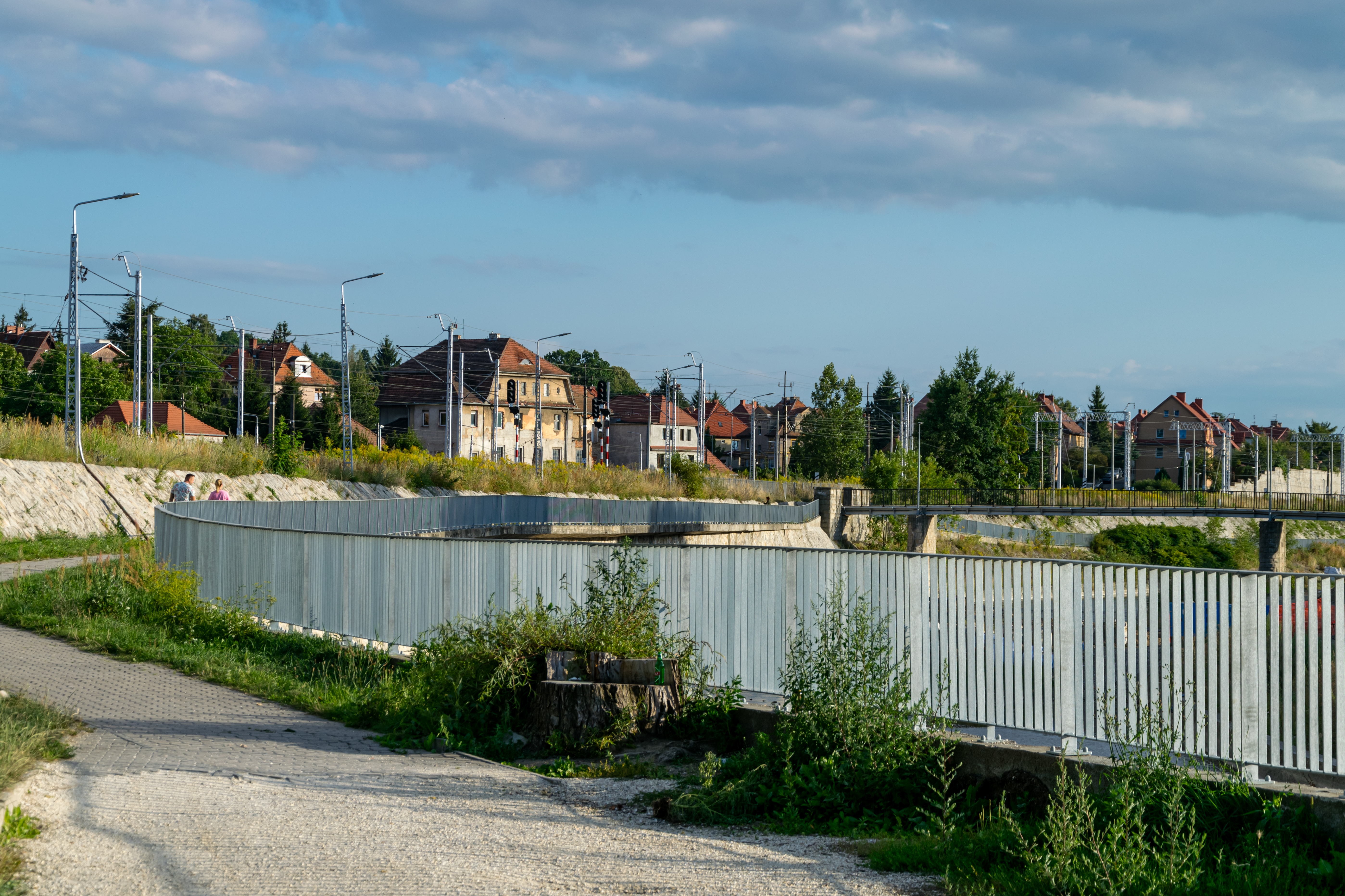 pathway sandwiched between railway tracks and a river