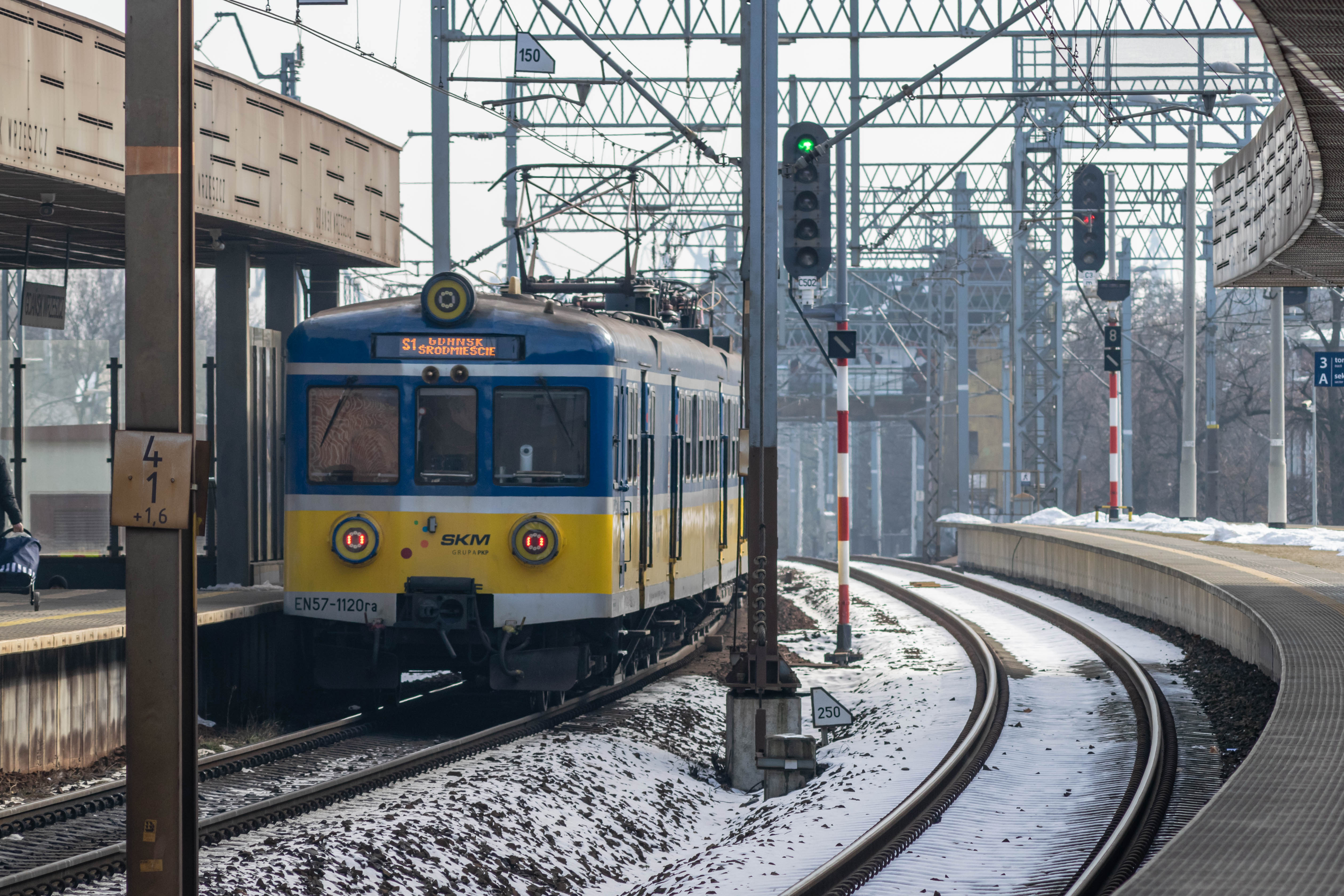 blue-yellow train departing the station