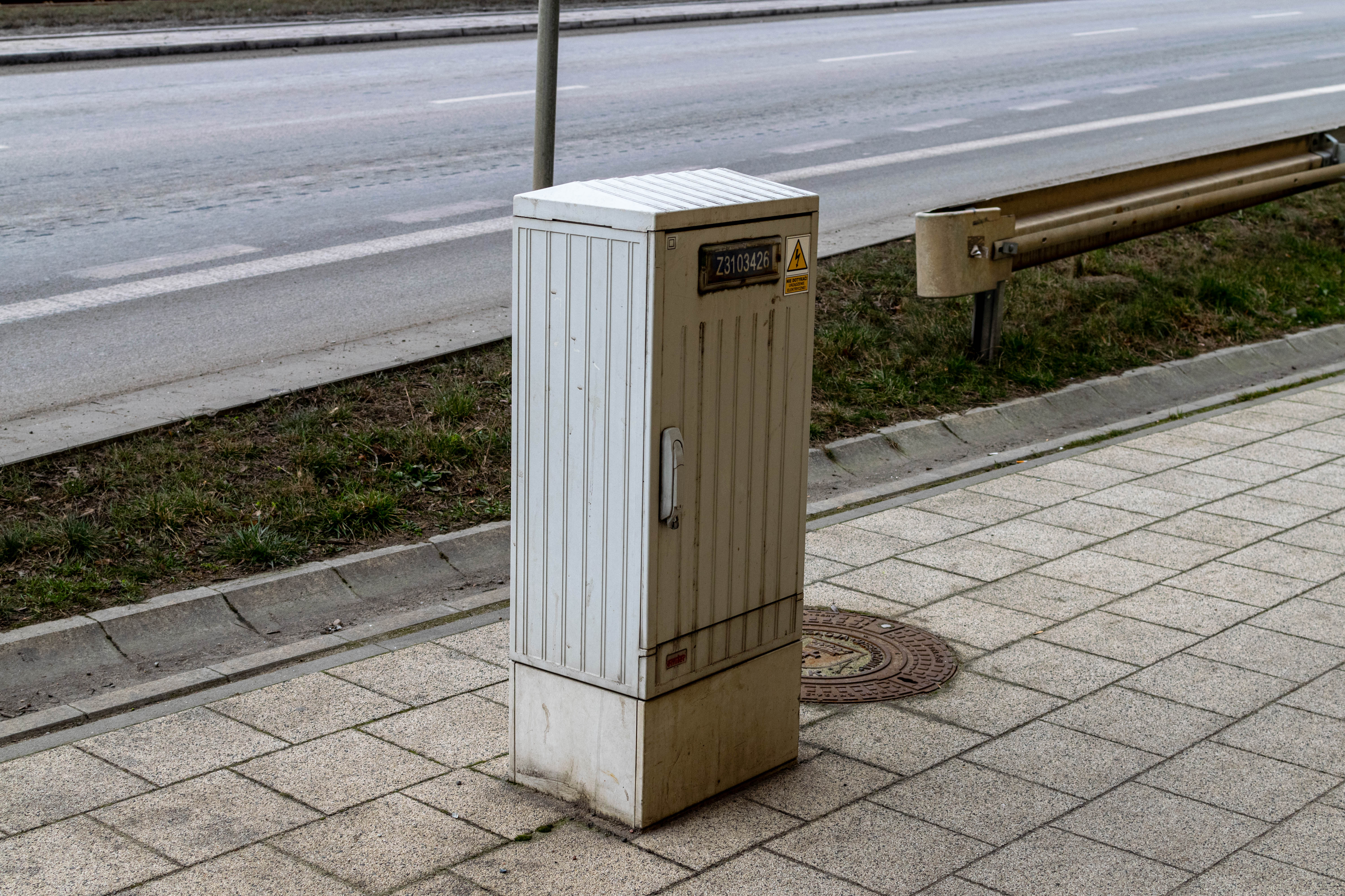 electrical cabinet standing in a middle of a sidewalk