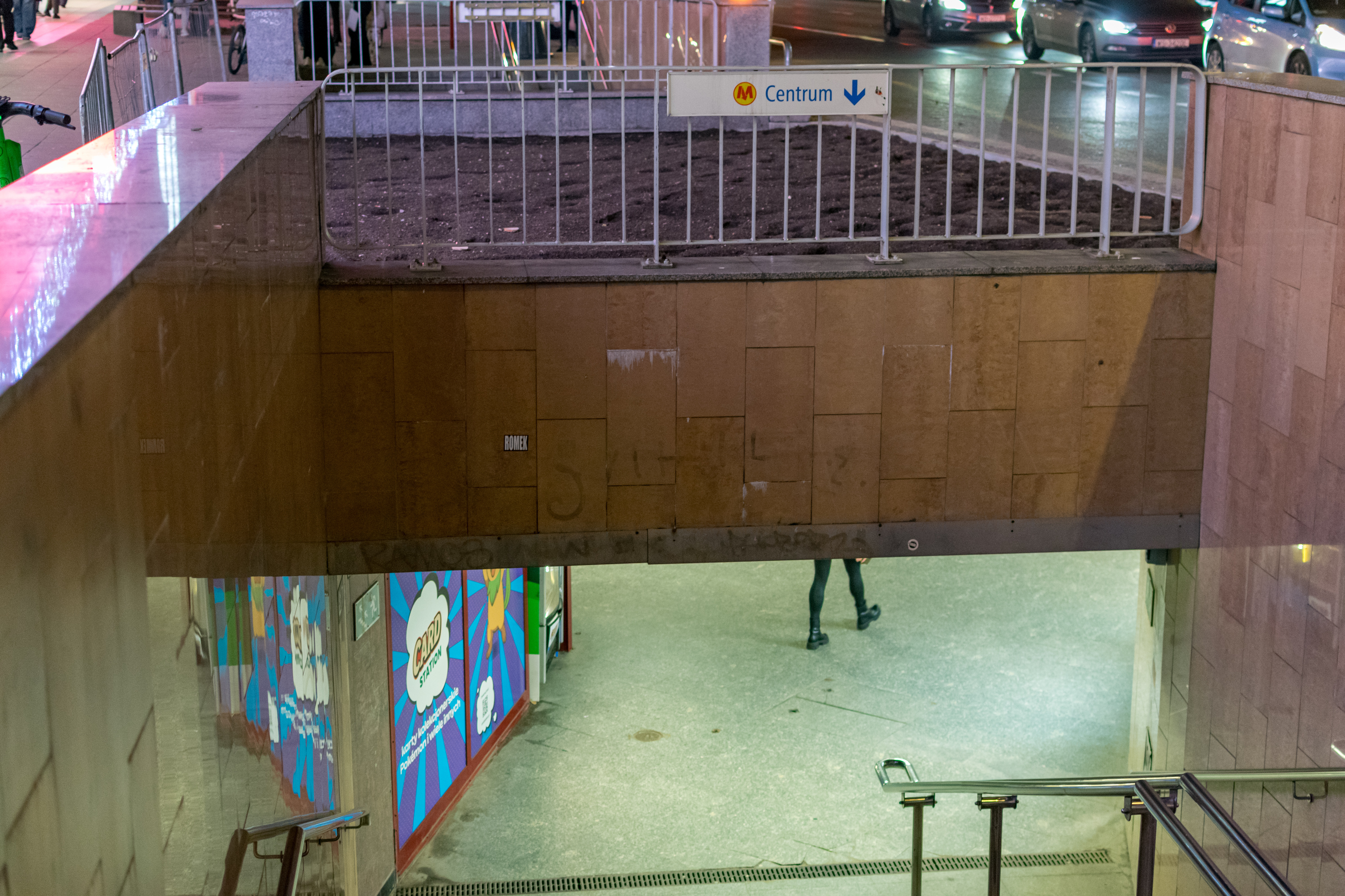 Stairs to subway under a street, with sign for metro station