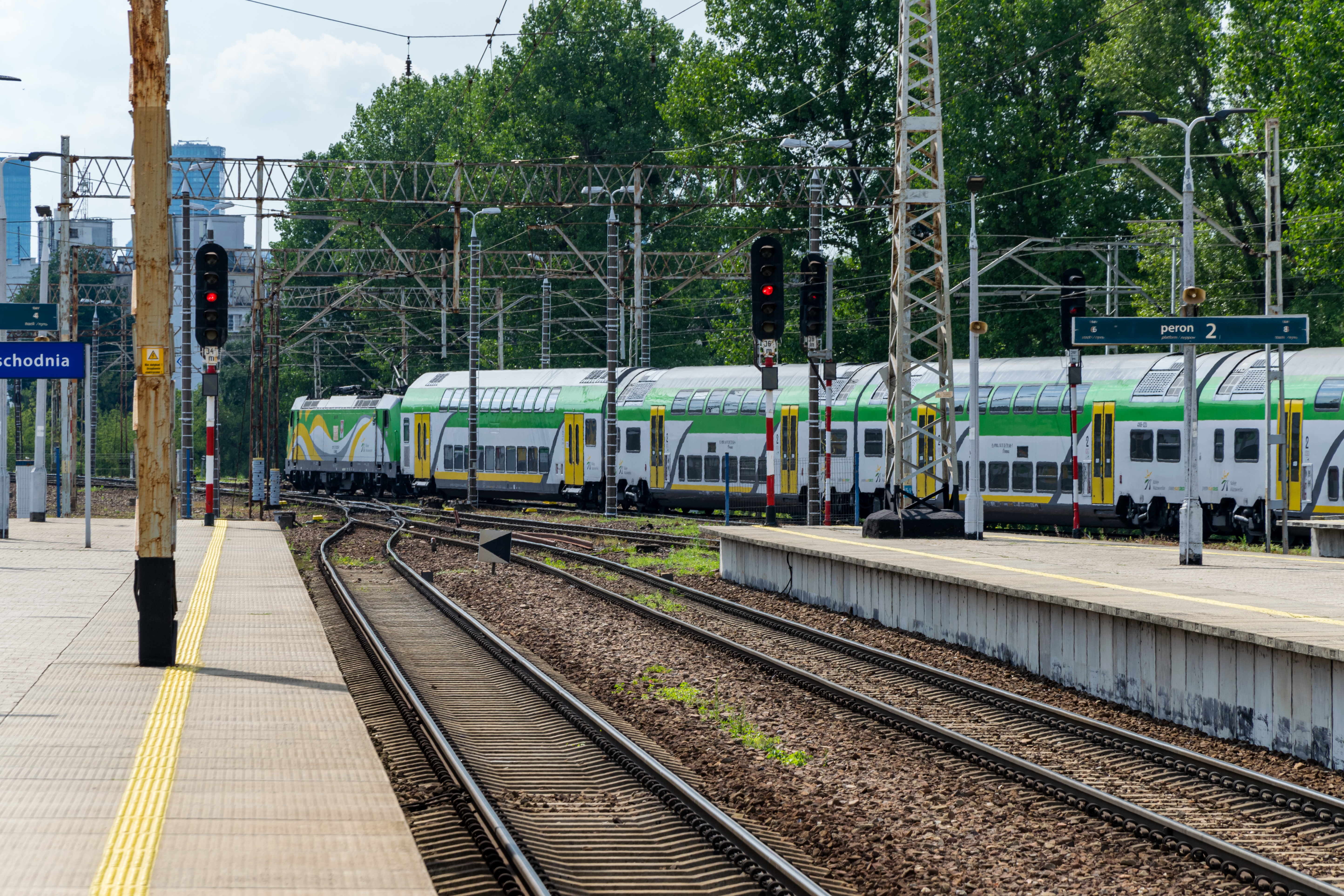 green-white double decker train leaving the station