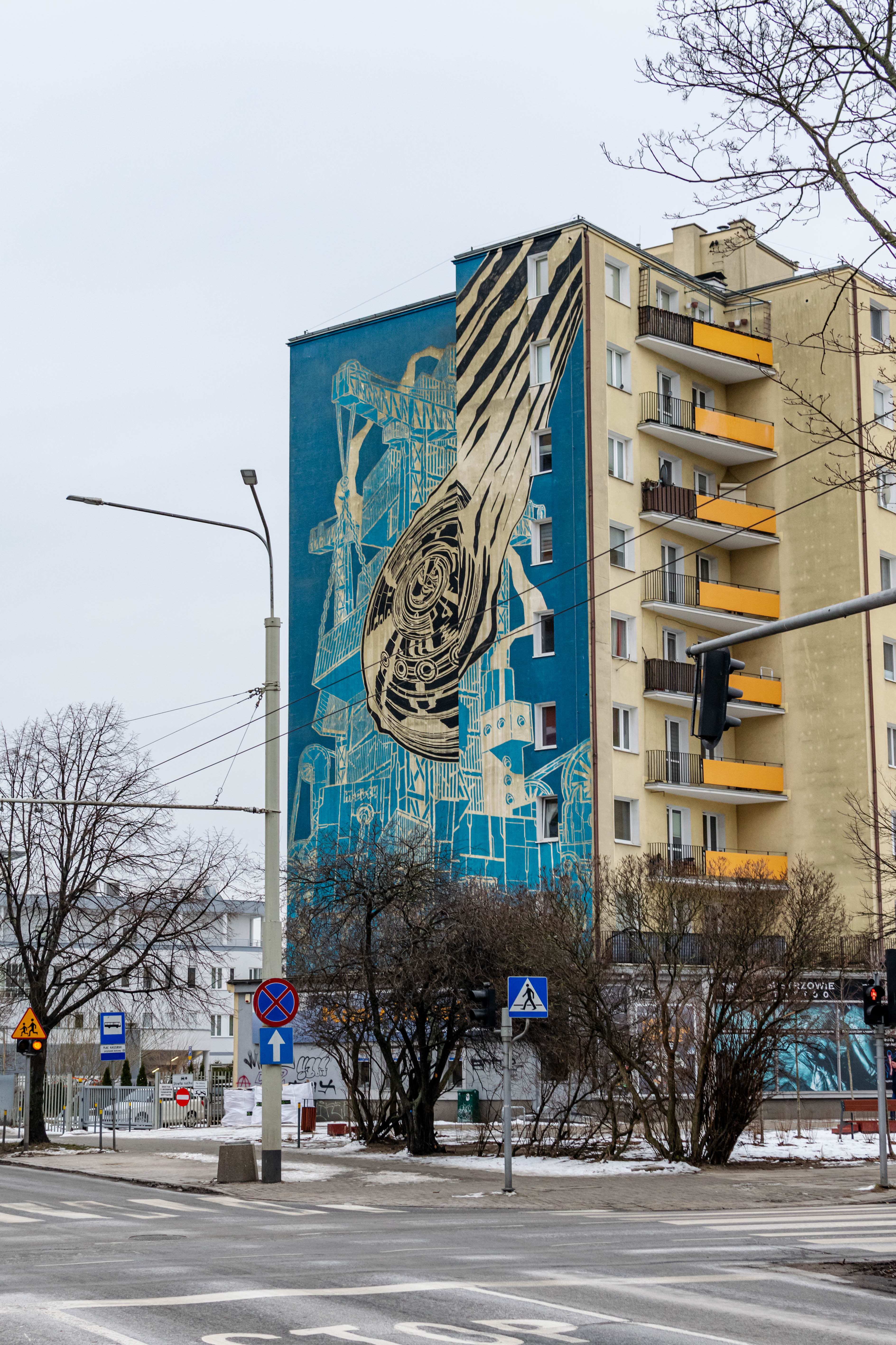 building with mural depicting port cranes with containers attached