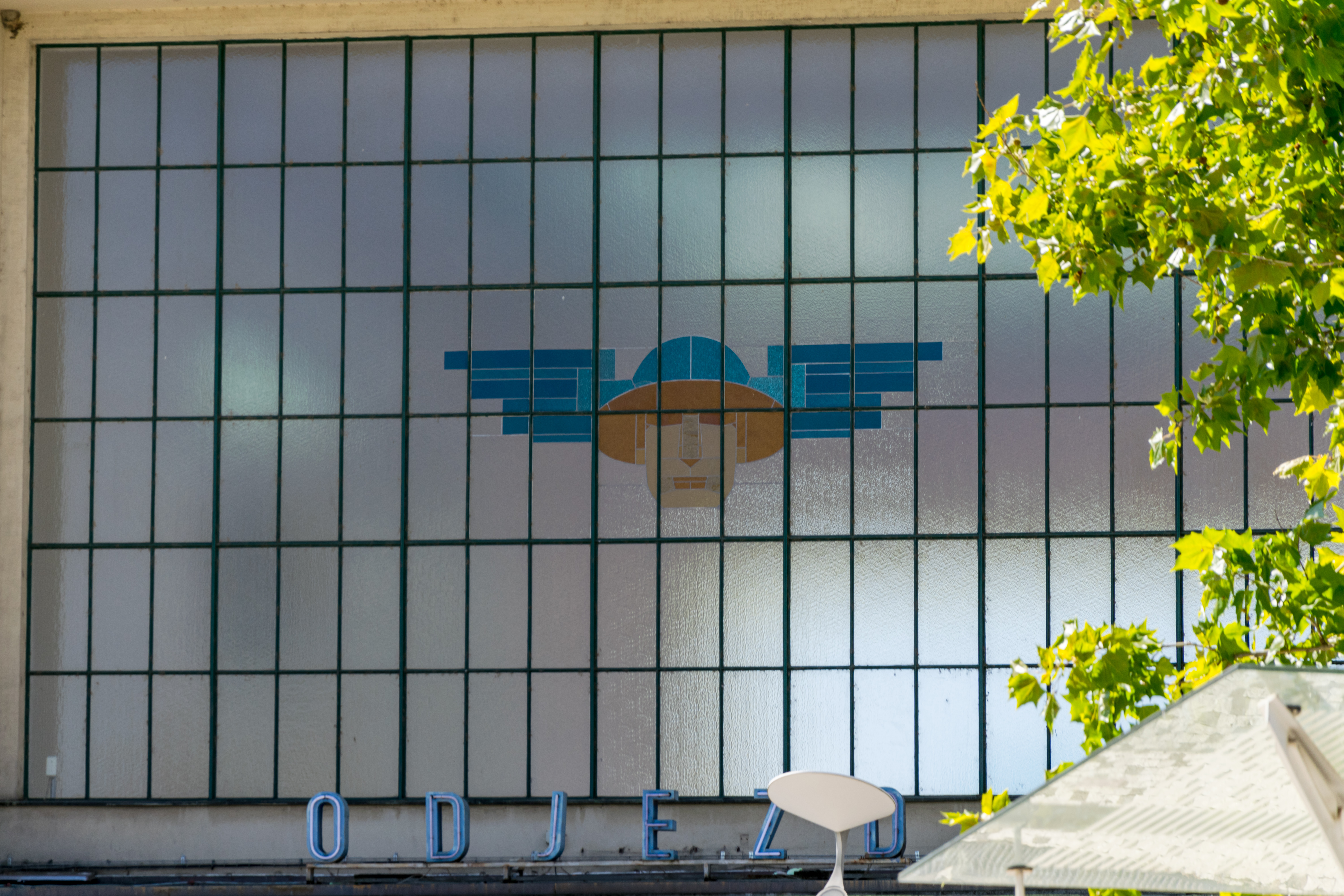 multi-glass pane window featuring a stylised graphic resembling a head of a worker wearing a blue helmet with wings