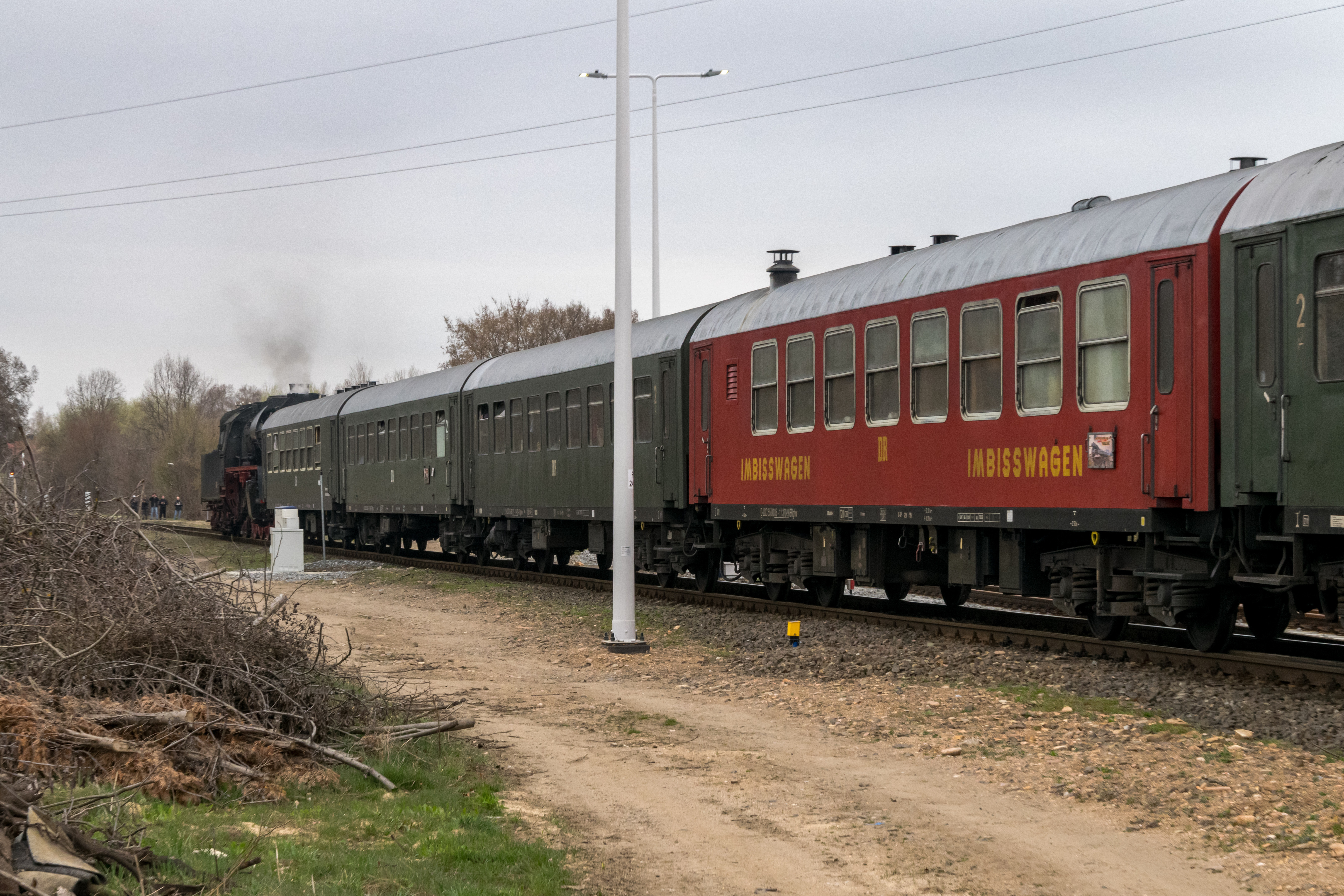 4 coaches shown, three brown passenger coaches and one red bar coach