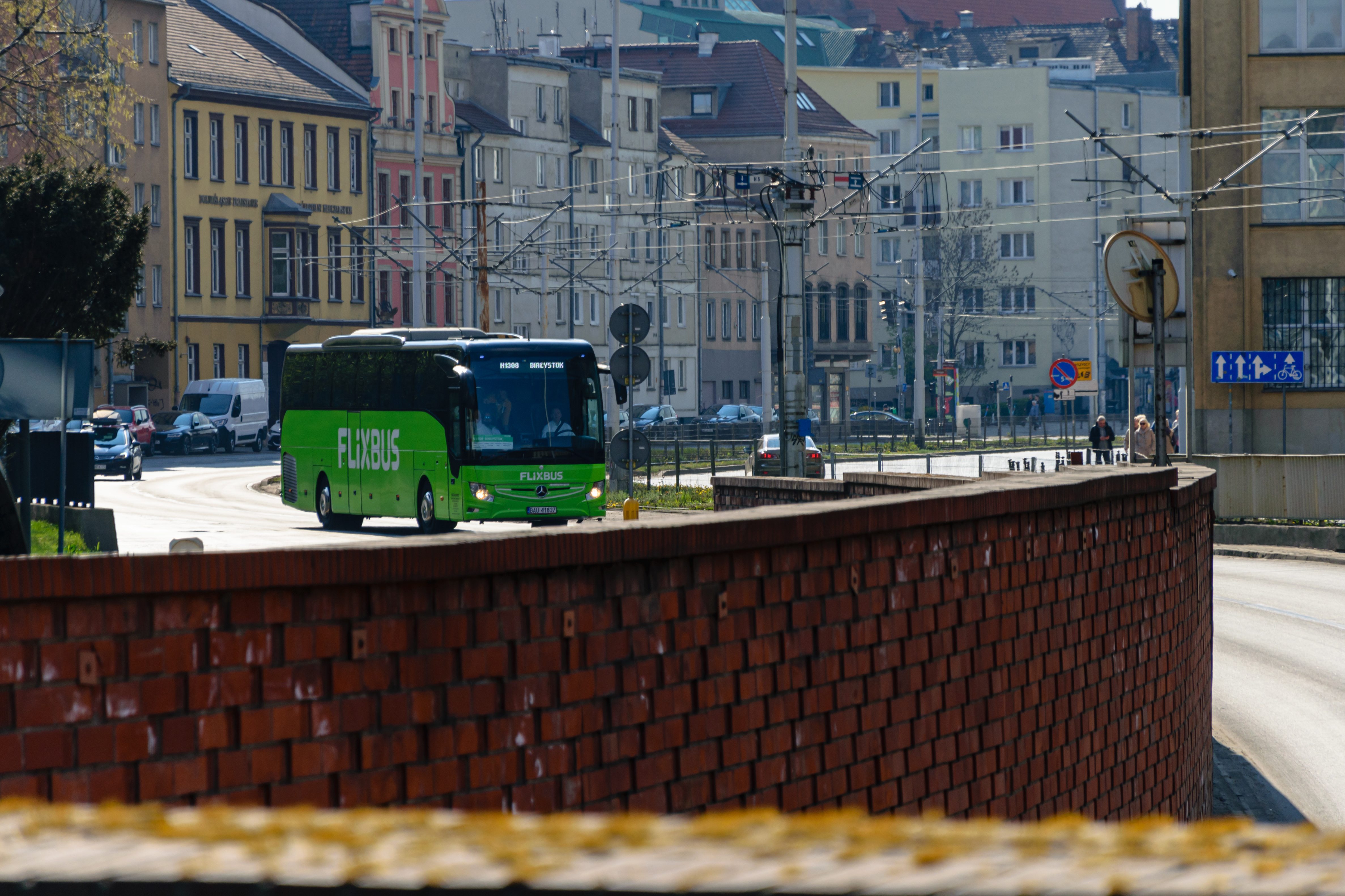Green bus in city centre preparing to enter an underpass