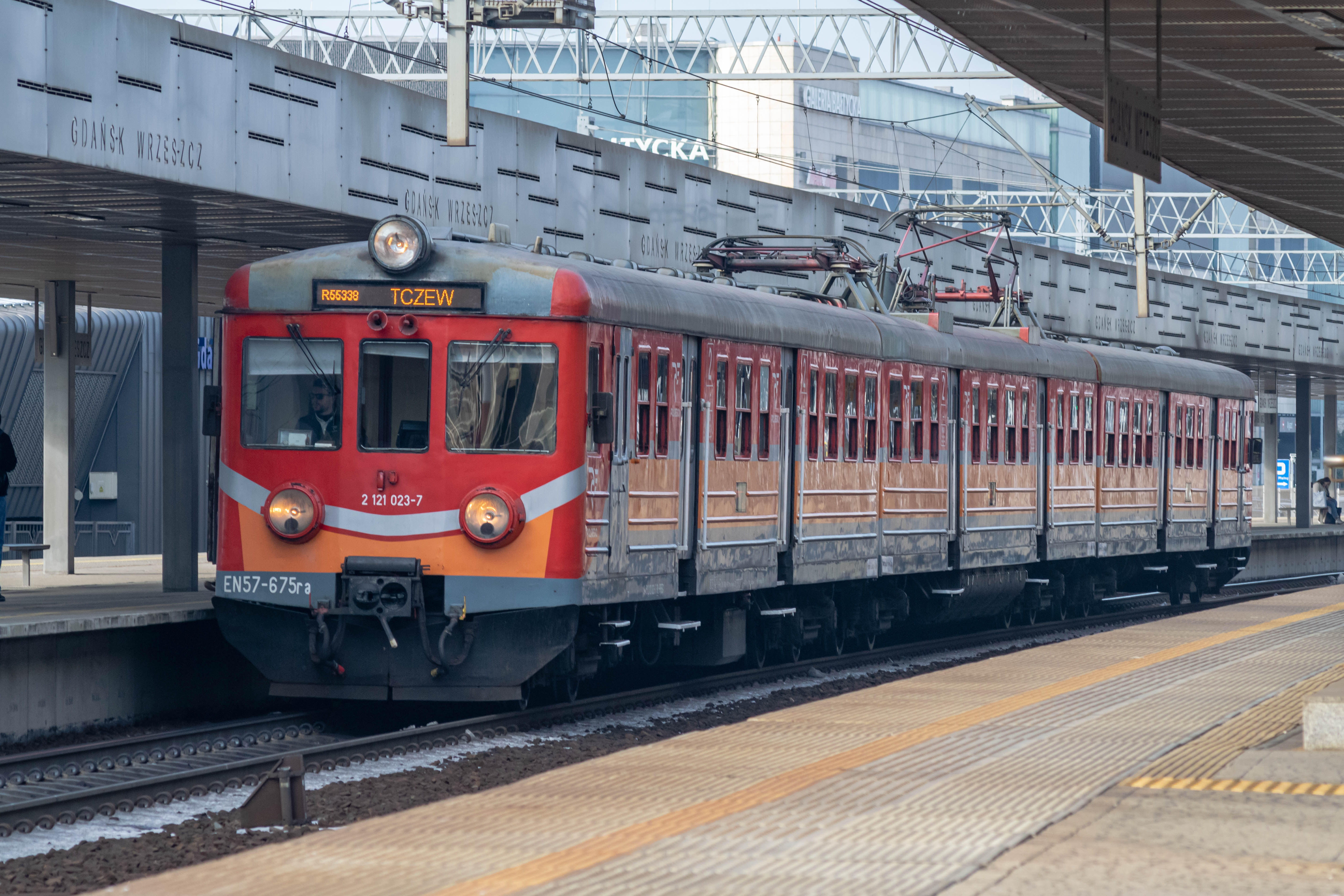 red-silver-orange train standing at a platform