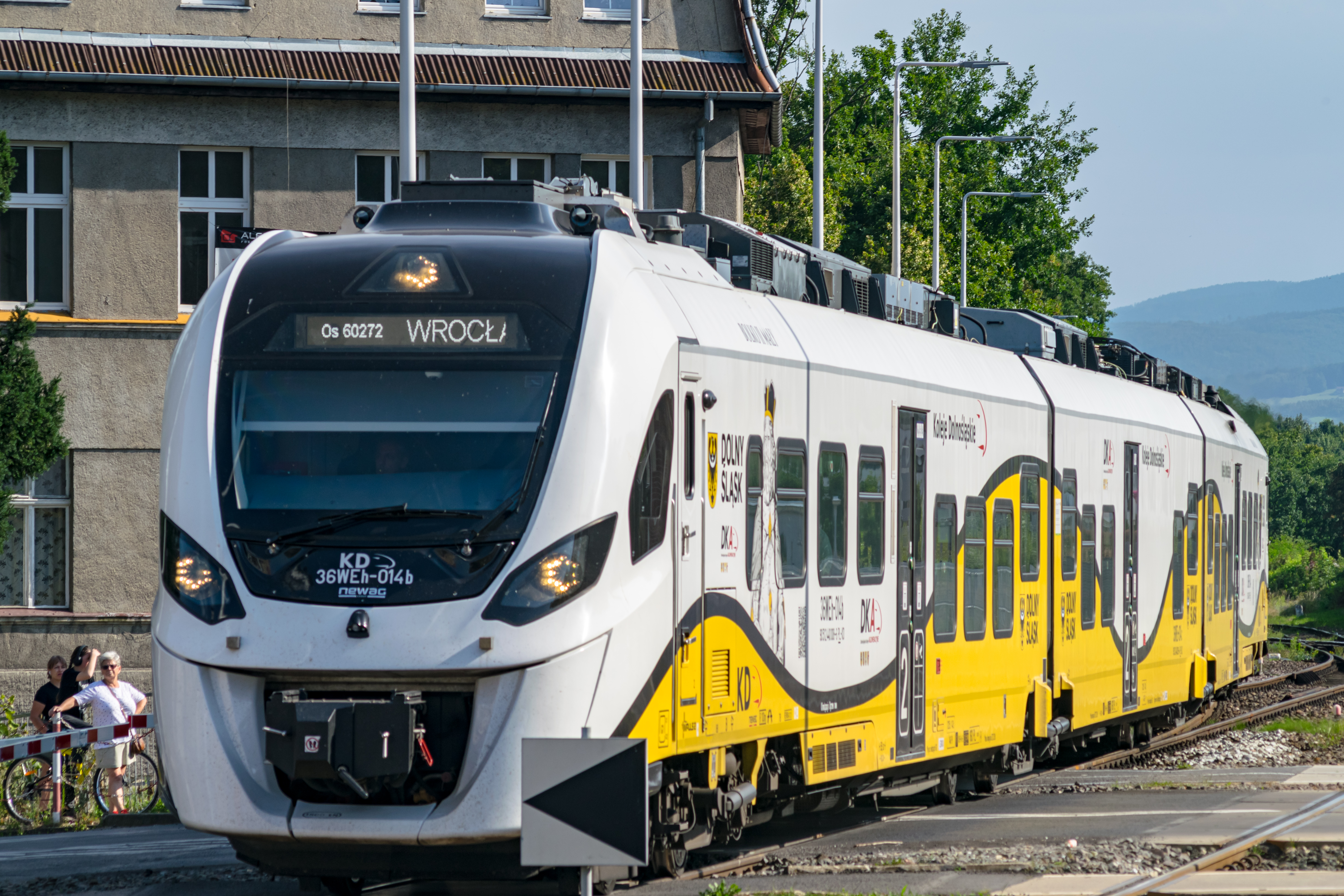 longer white-yellow train entering the station