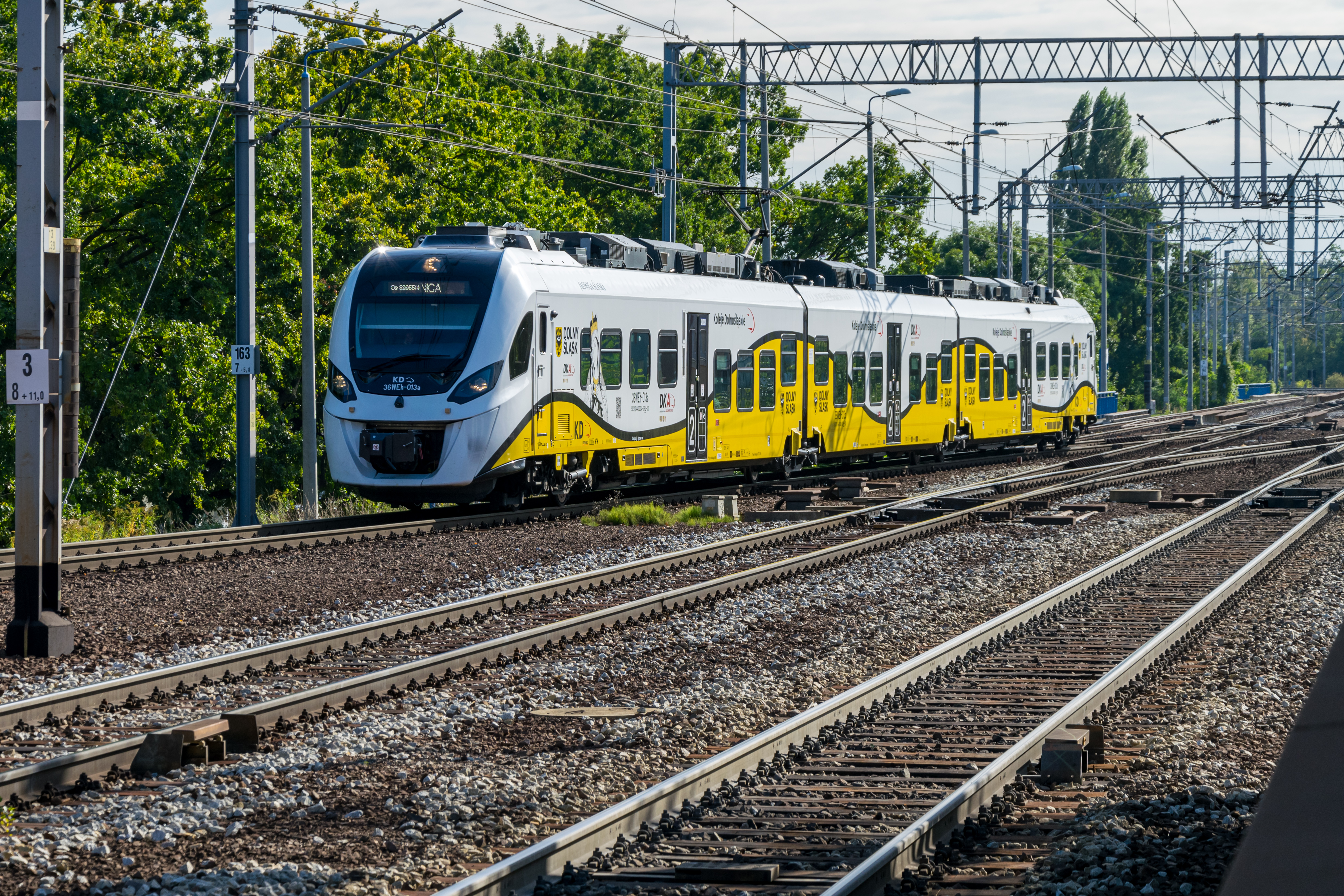 Yellow-red Impuls II 36WEh arriving at a station