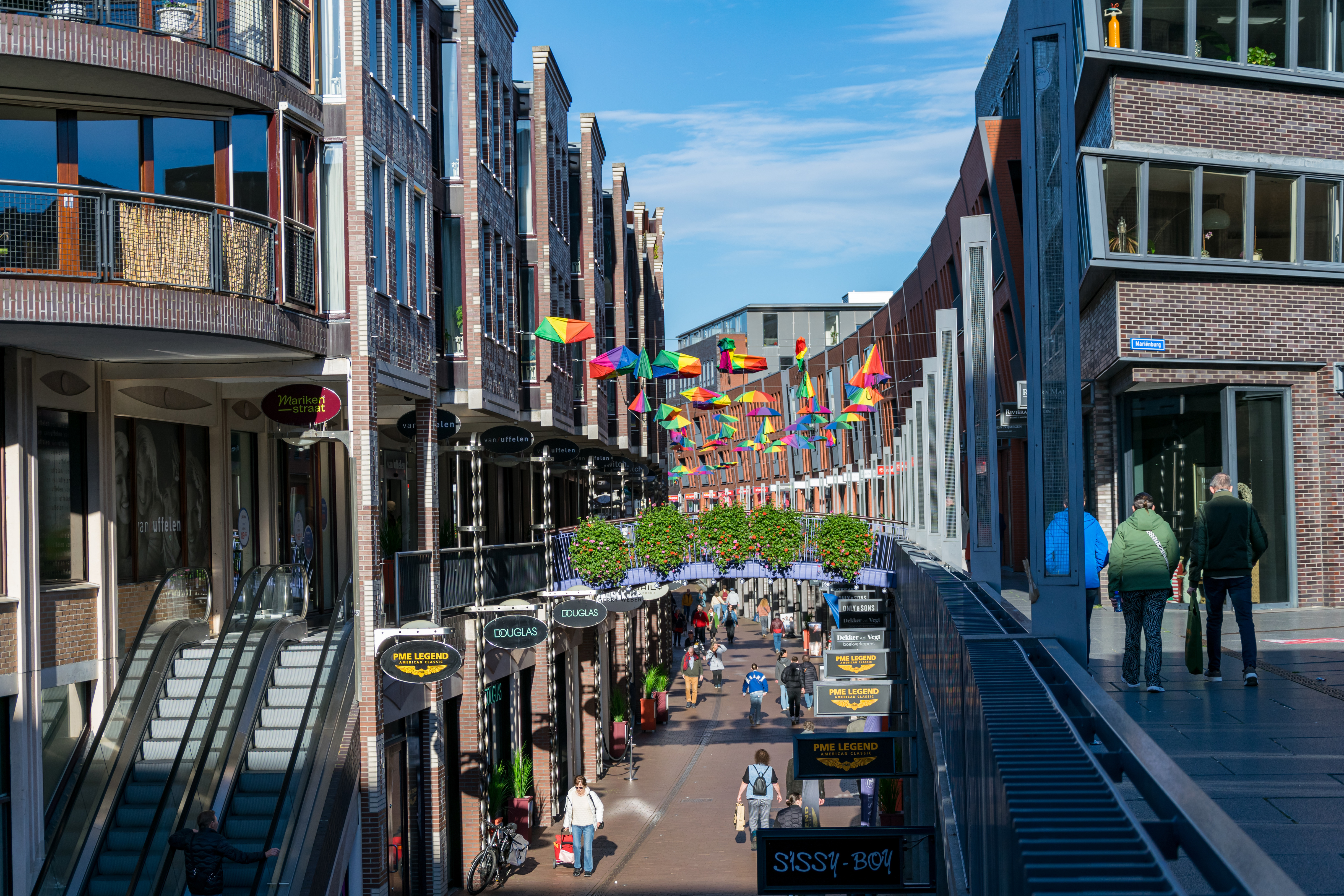 double decker(?) street with shops and all that stuff, there’s a lot of rainbow umbrellas over it