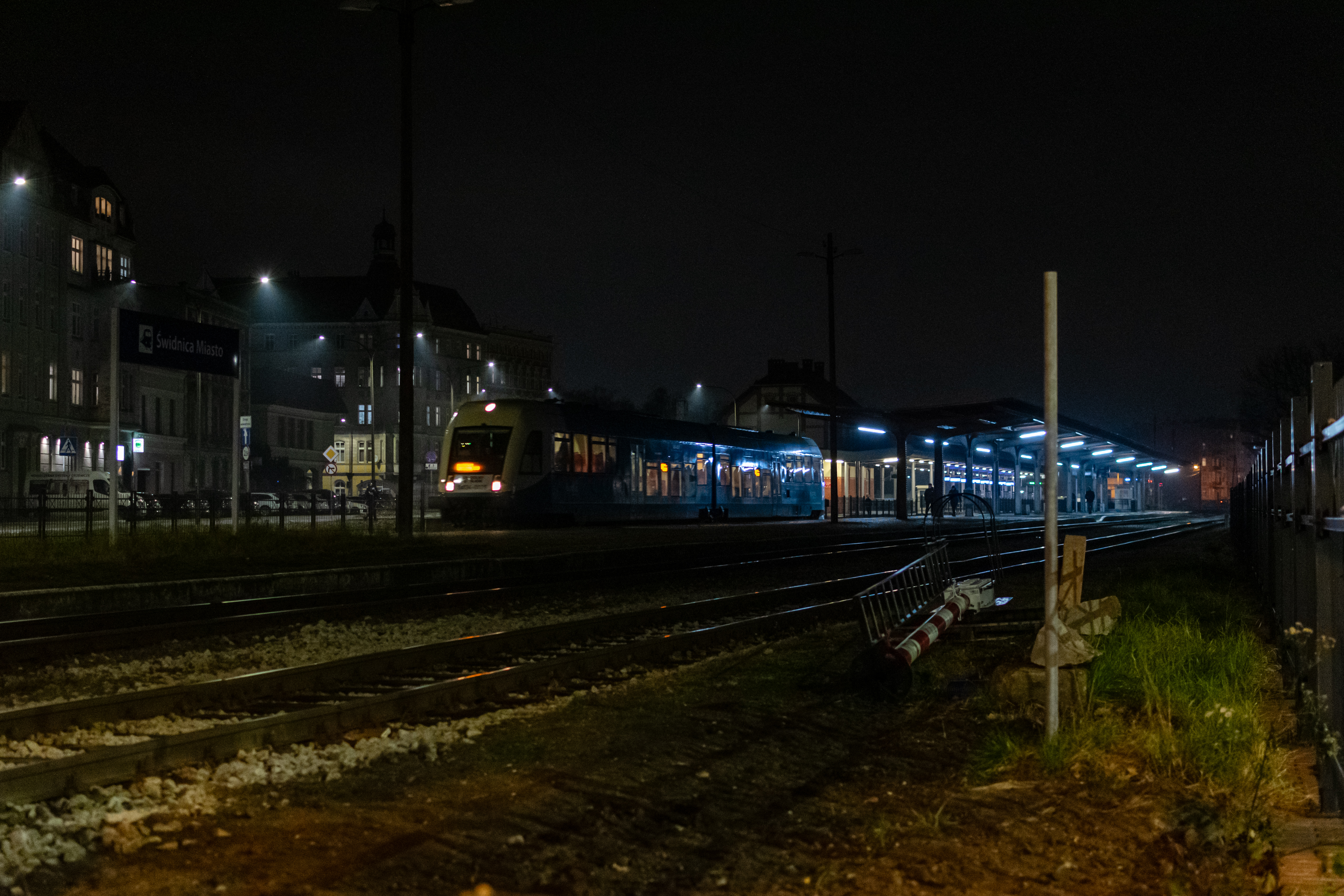 blue-white train leaving a train station at night
