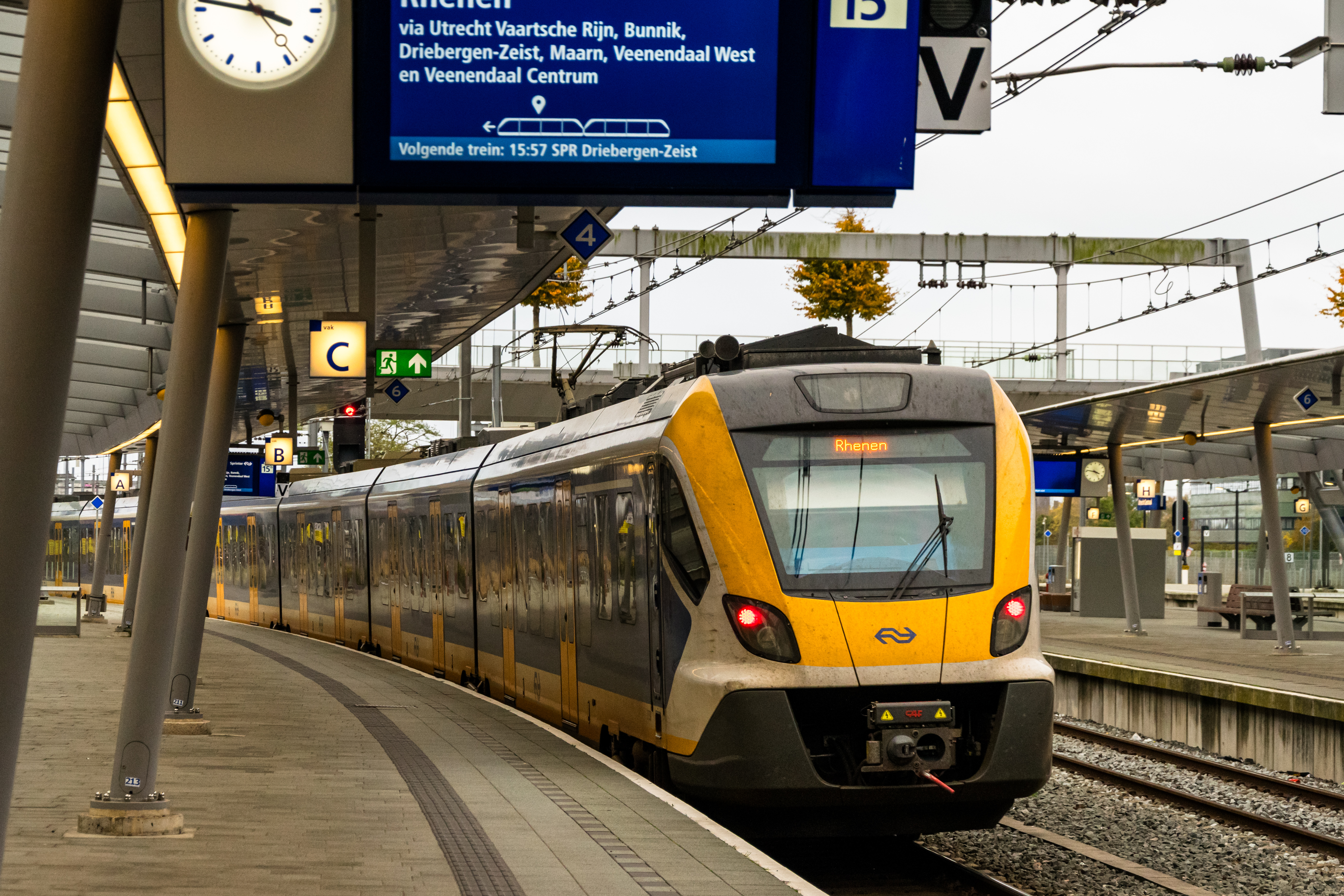 yellow-blue-white train departing