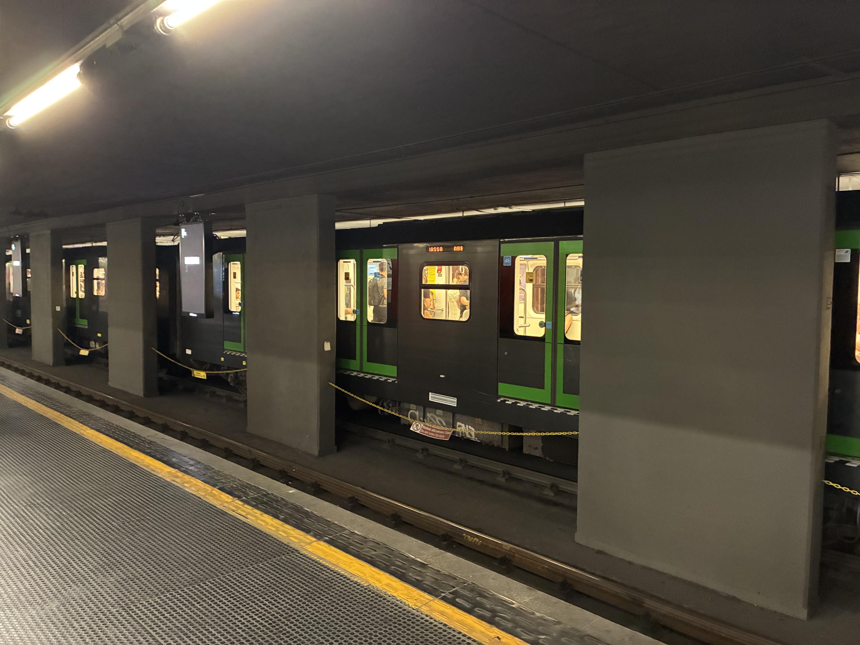 metro tunnel, with wide pillars in the middle and a metro train in the opposite direction waiting at the platforms
