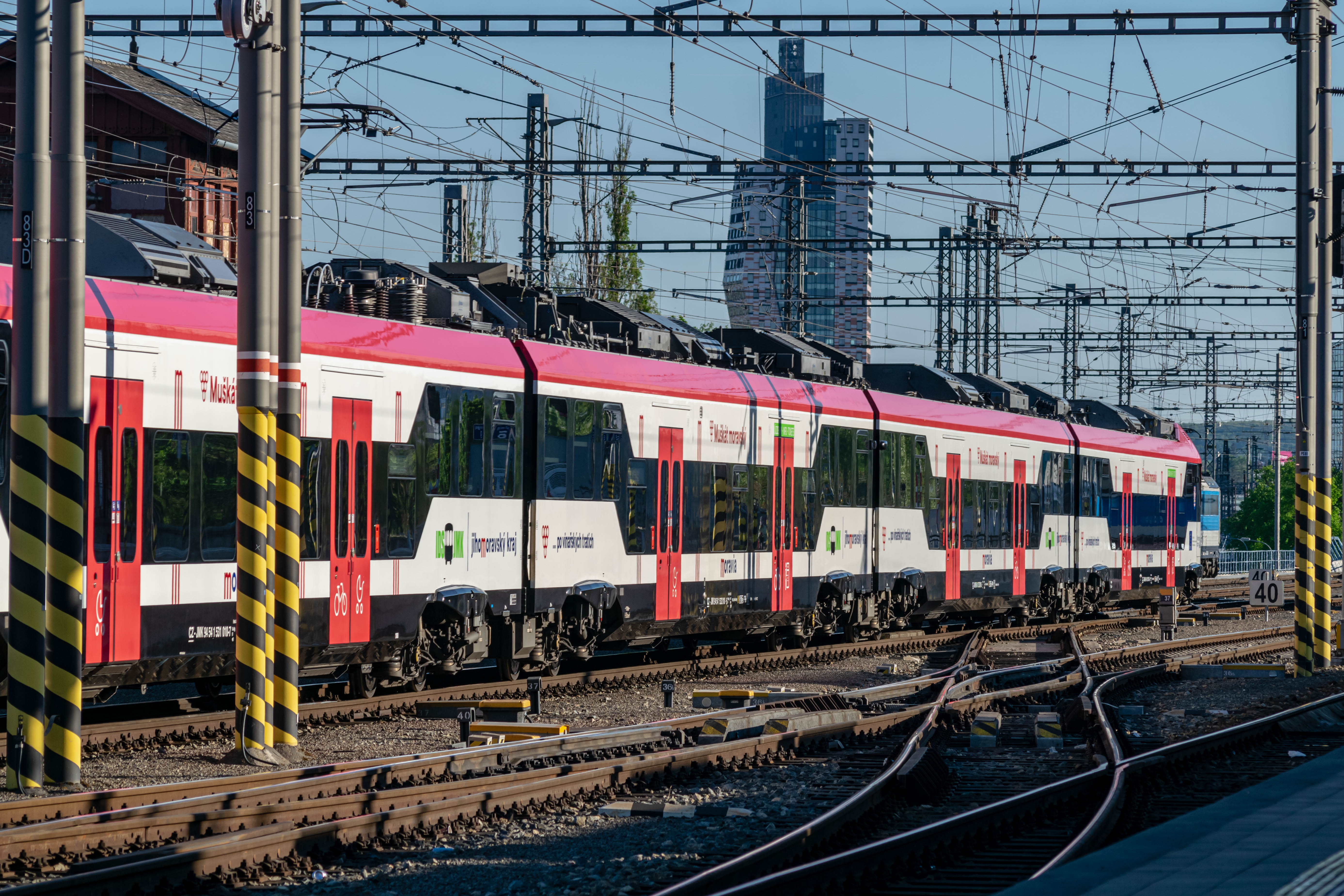 white-black-red EMU leaving the station