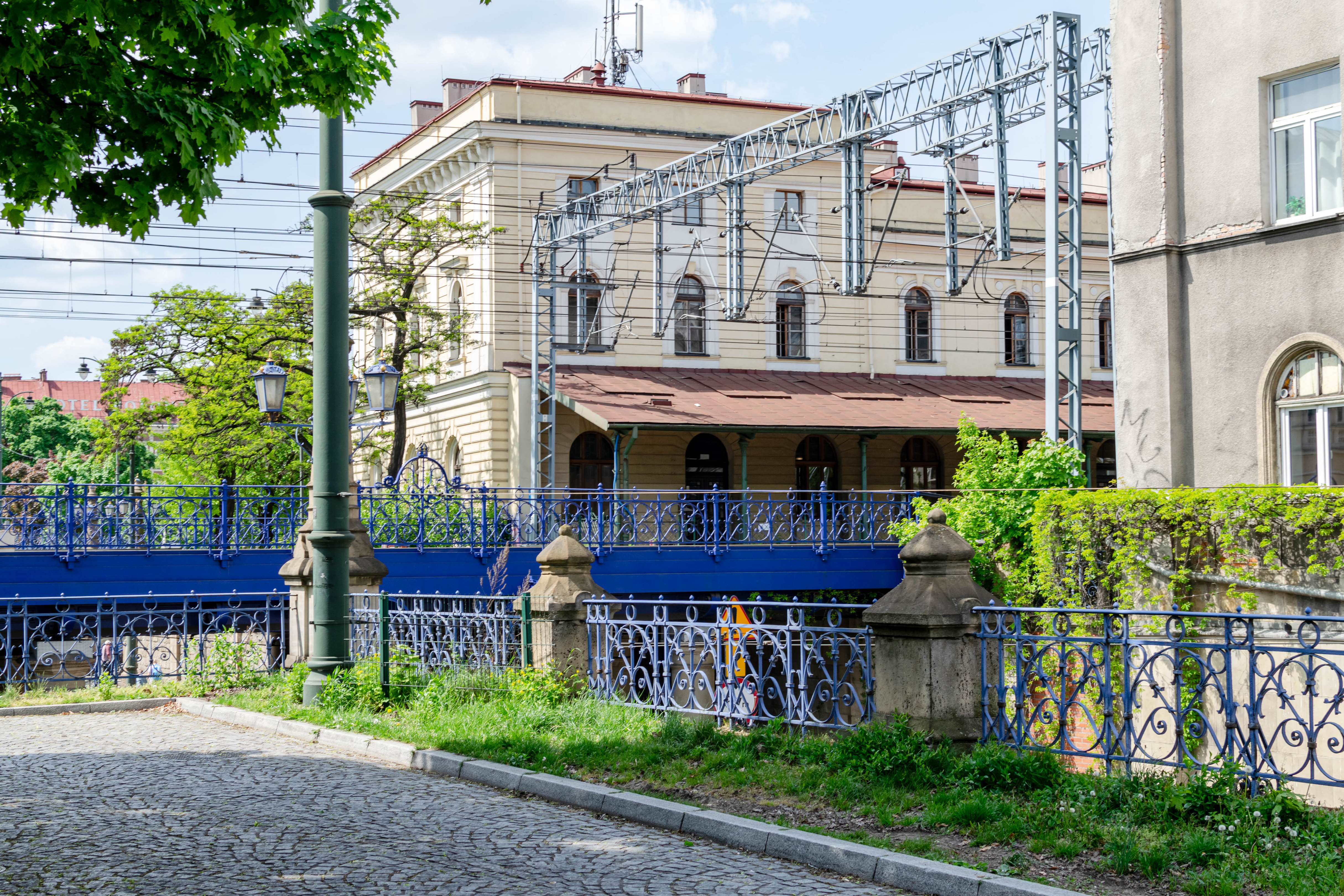 Blue electrified railway viaduct between buildings and plazas