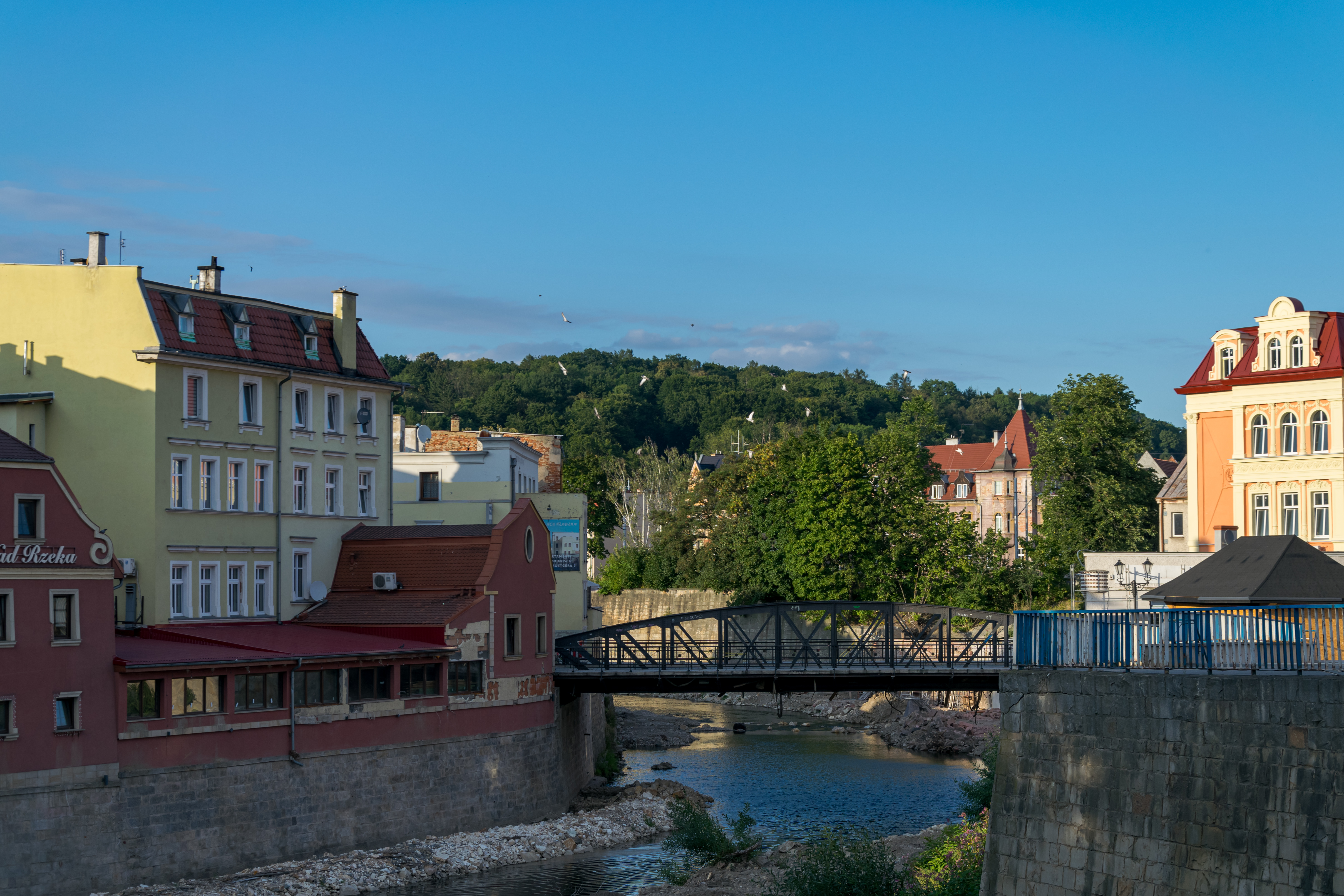 town scene divided by a river with old buildings on both sides, and a mountain in the background