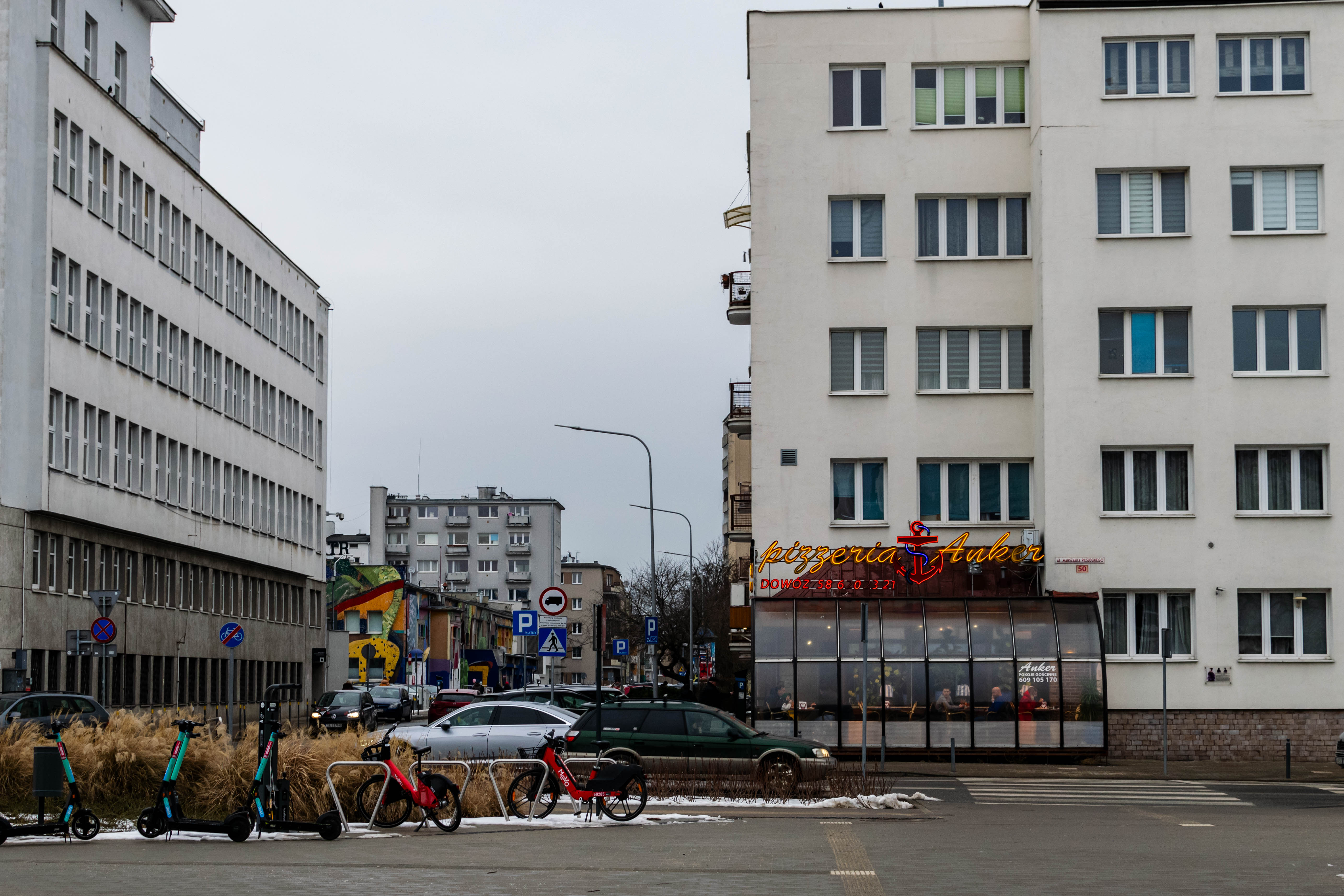 a bunch of blocks, one on the right has a pizza place with a neon sign attached to it