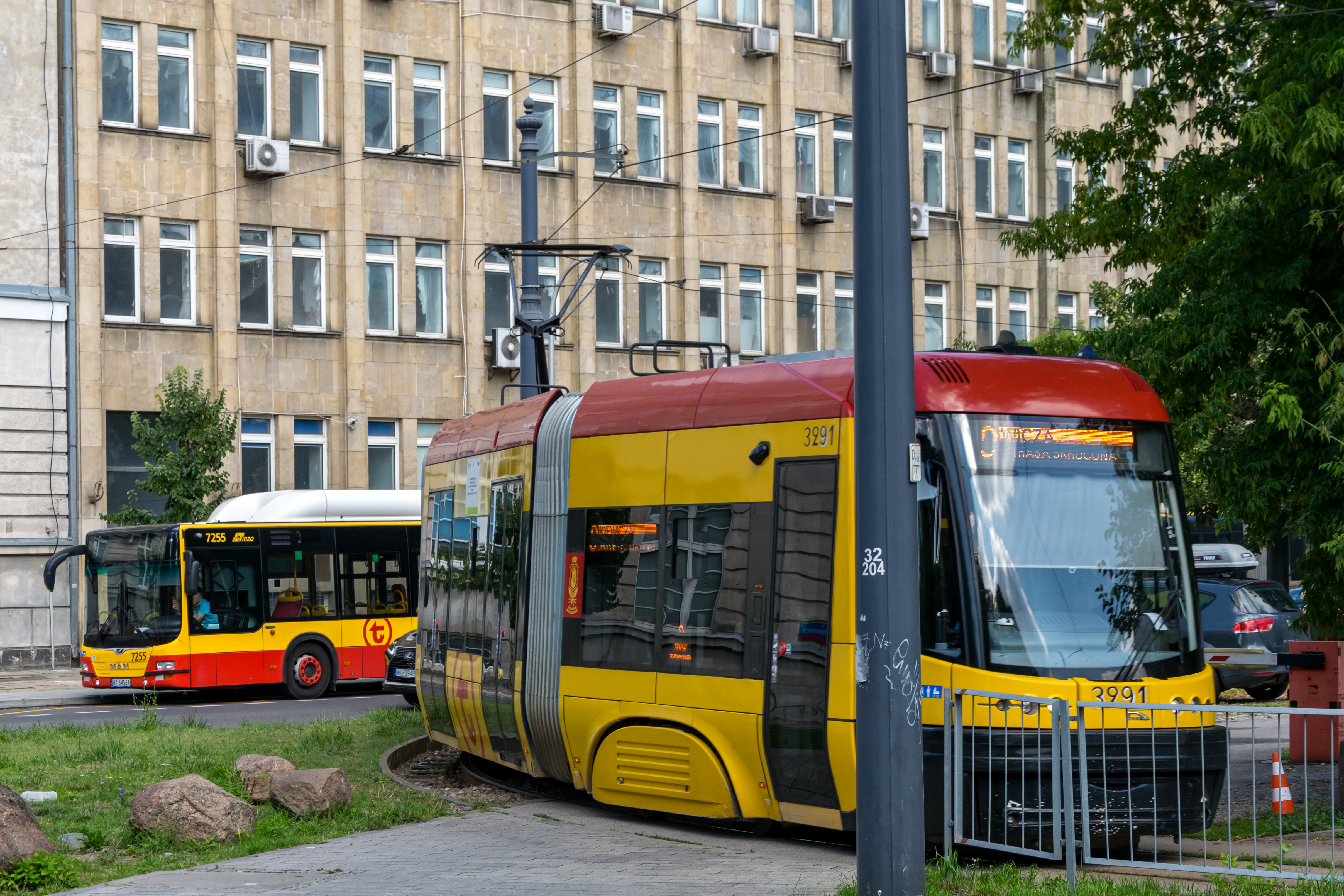 yellow-red tram with a yellow-red bus behind