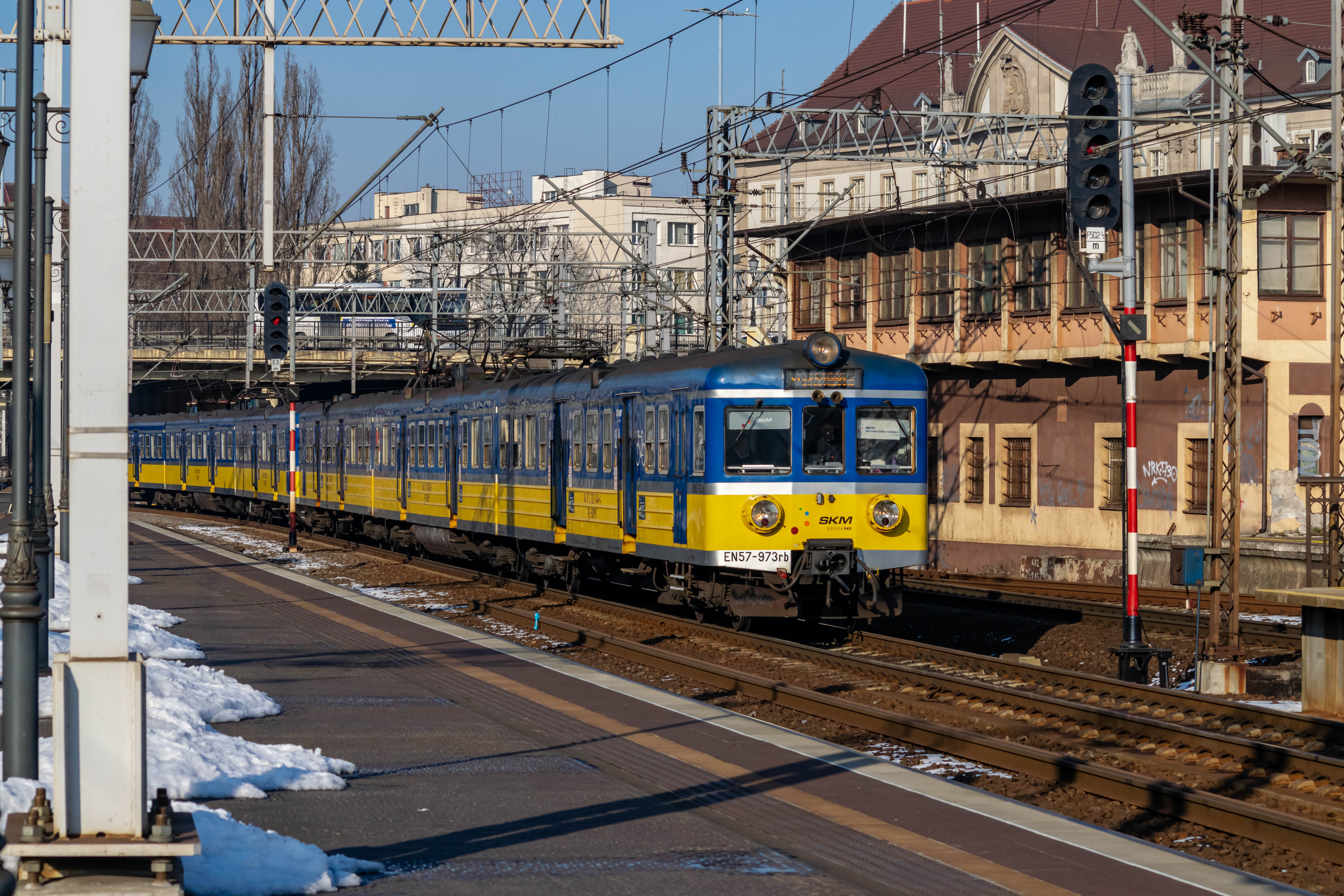 blue-yellow old train with silver accents, arriving into the station