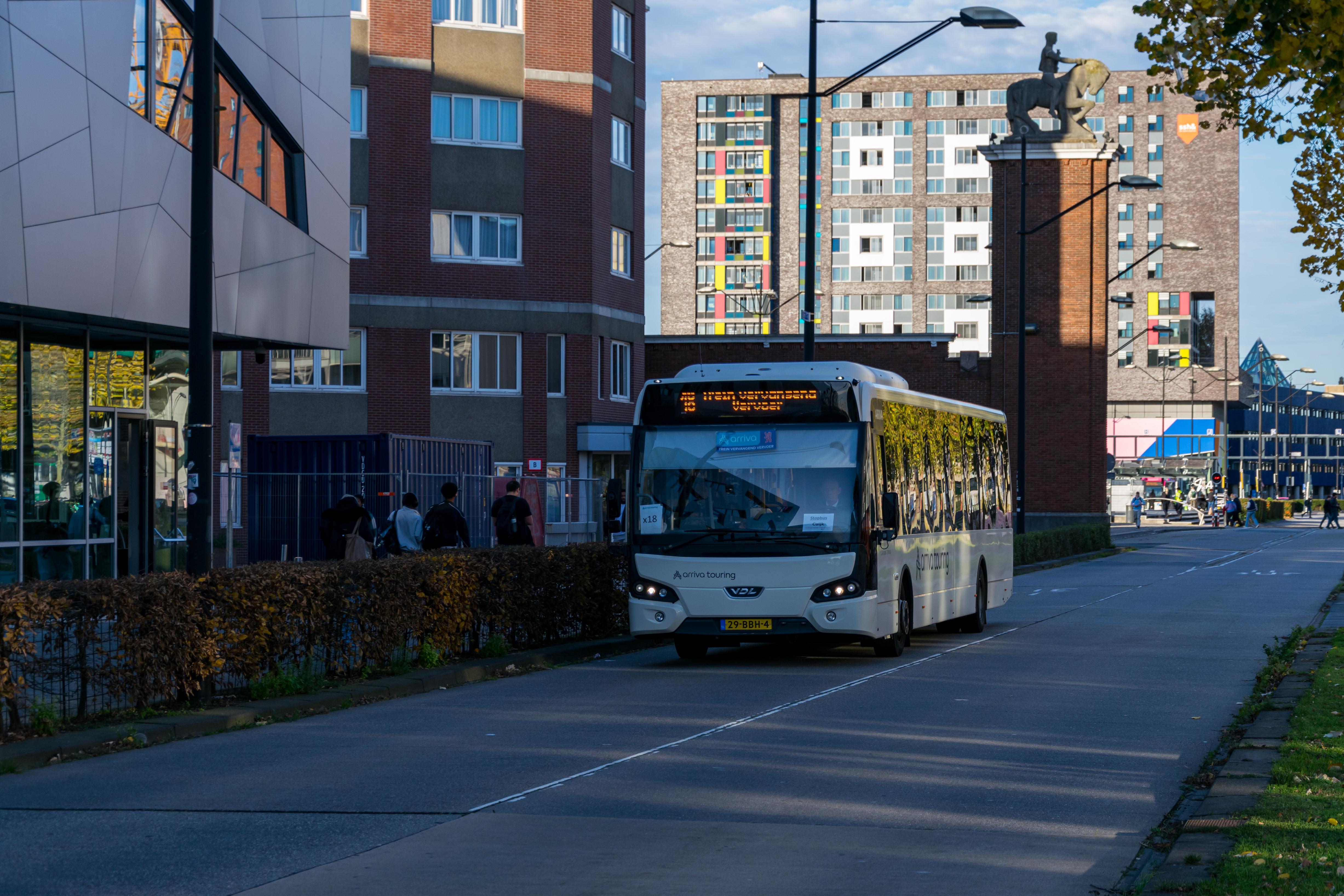 Another bus on a busway but is closer to the train station
