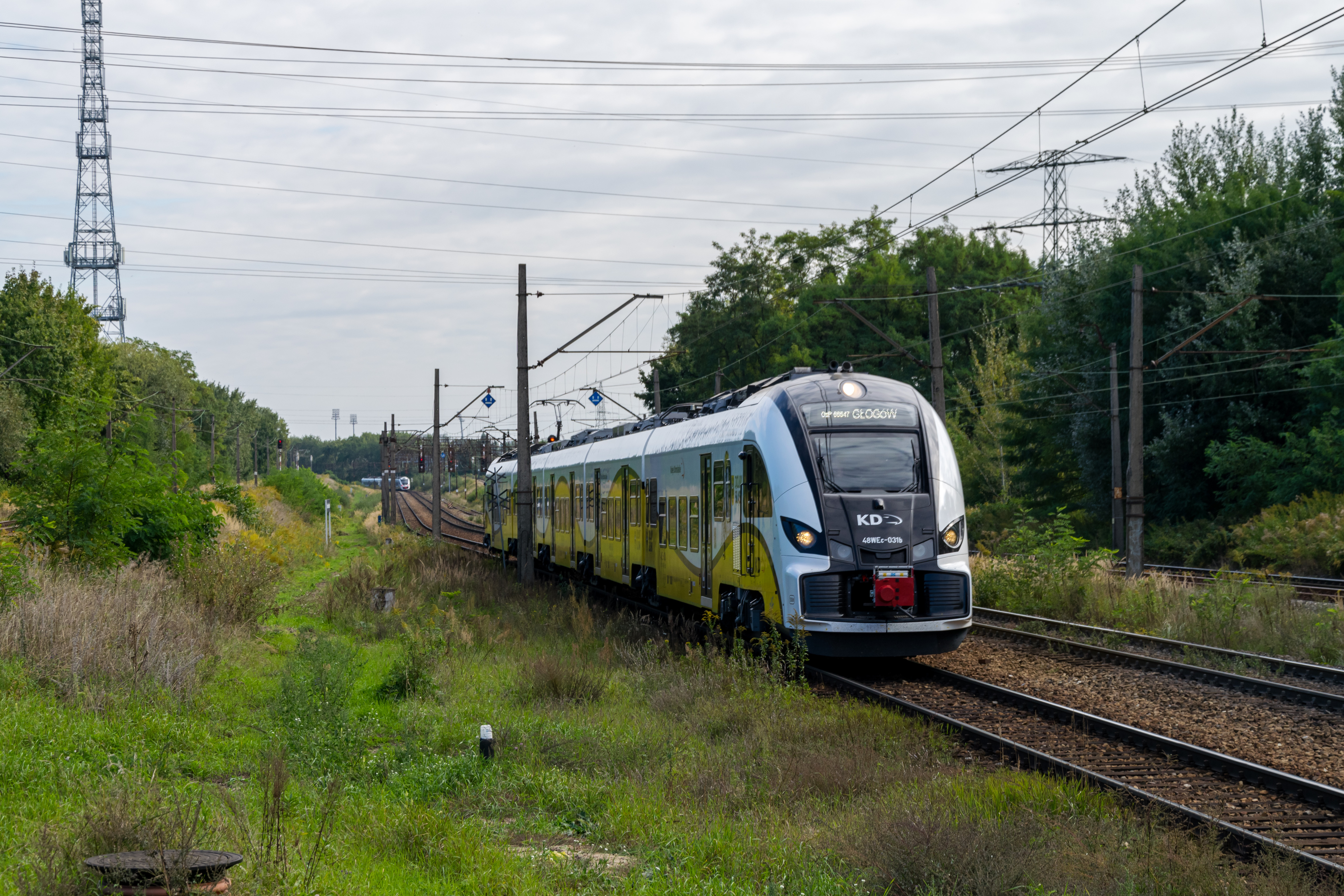 Yellow-white Elf II 48WEc arriving at a station