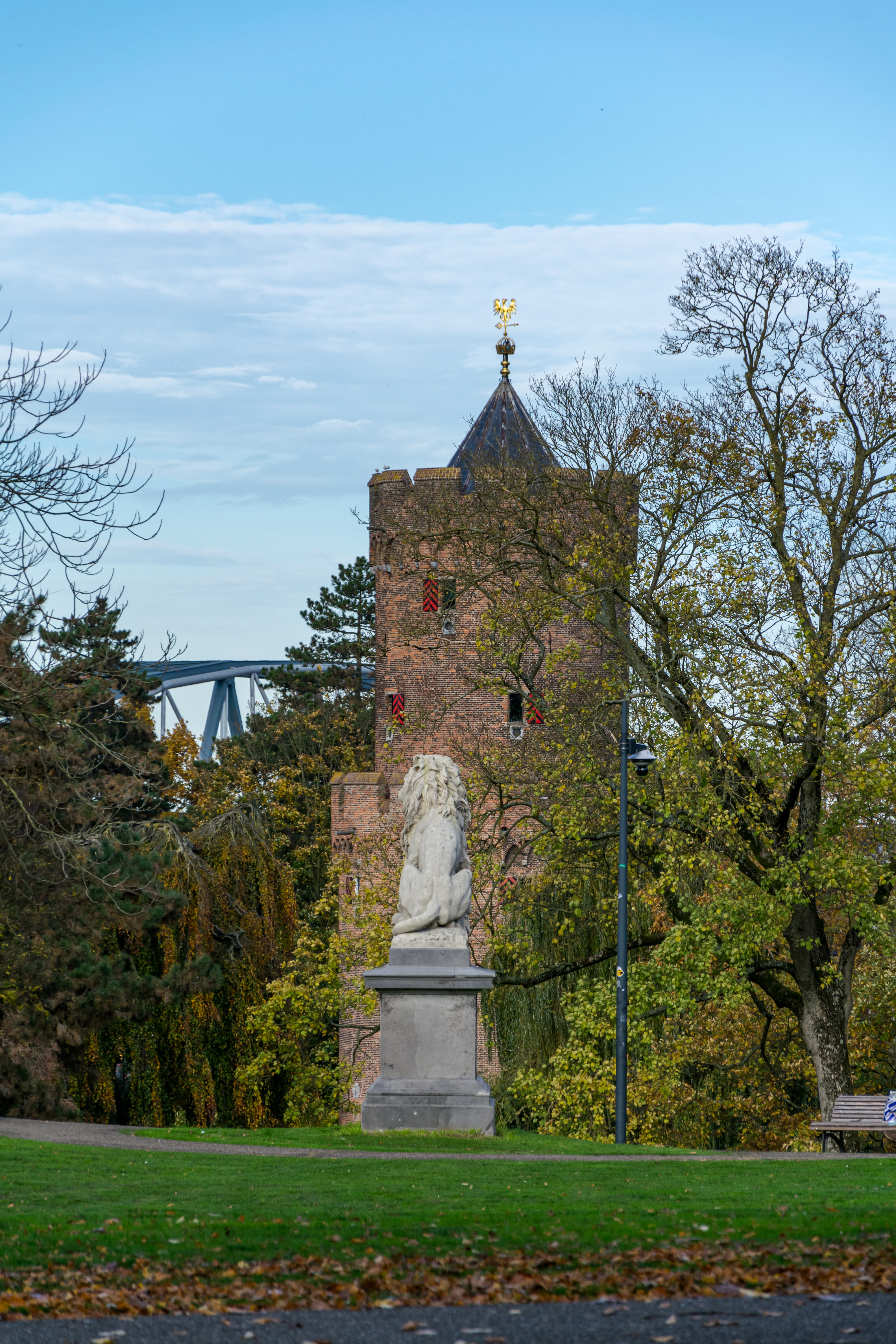 Back of a lion statue, with a tower in the background