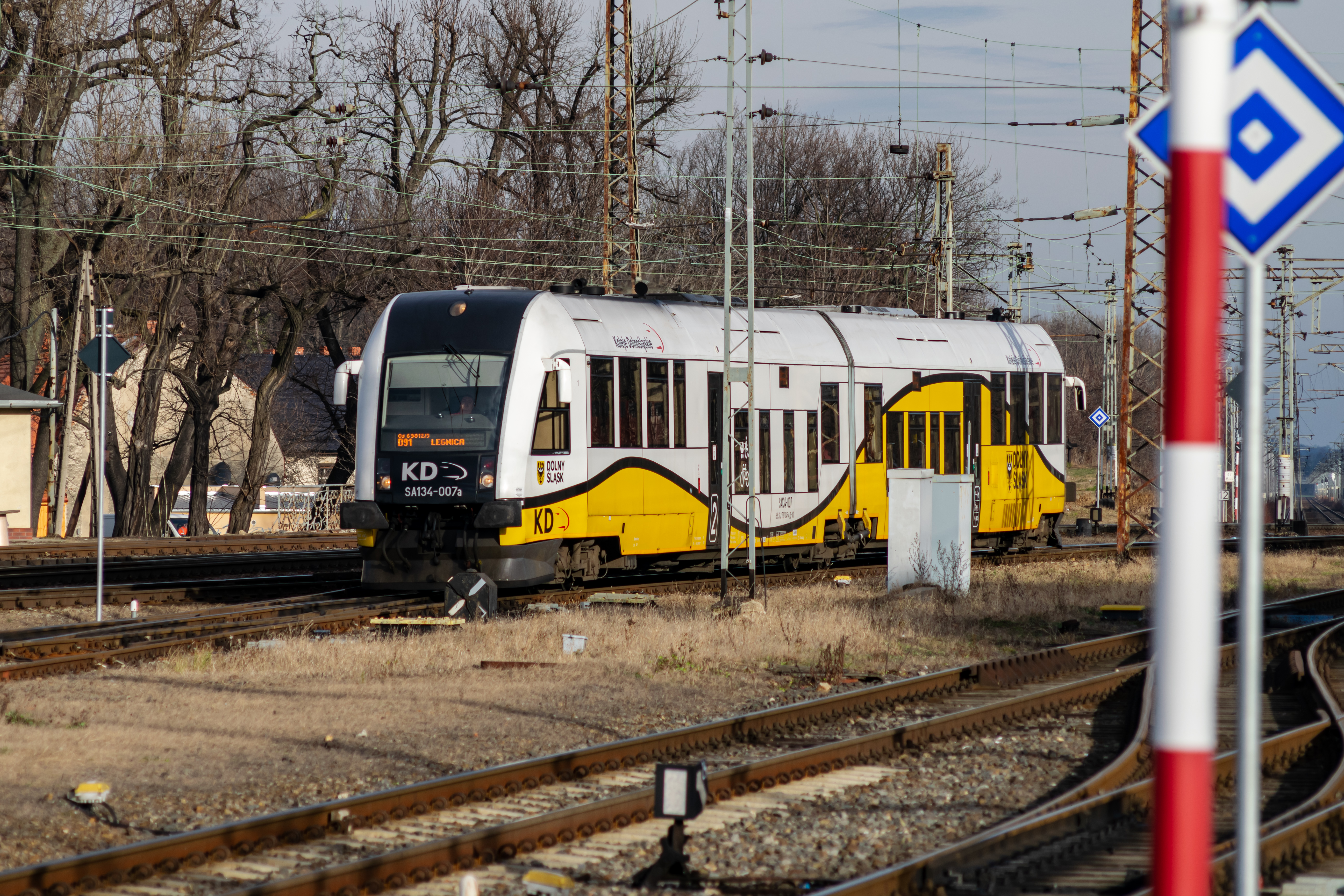 yellow-black-white train arriving at the station