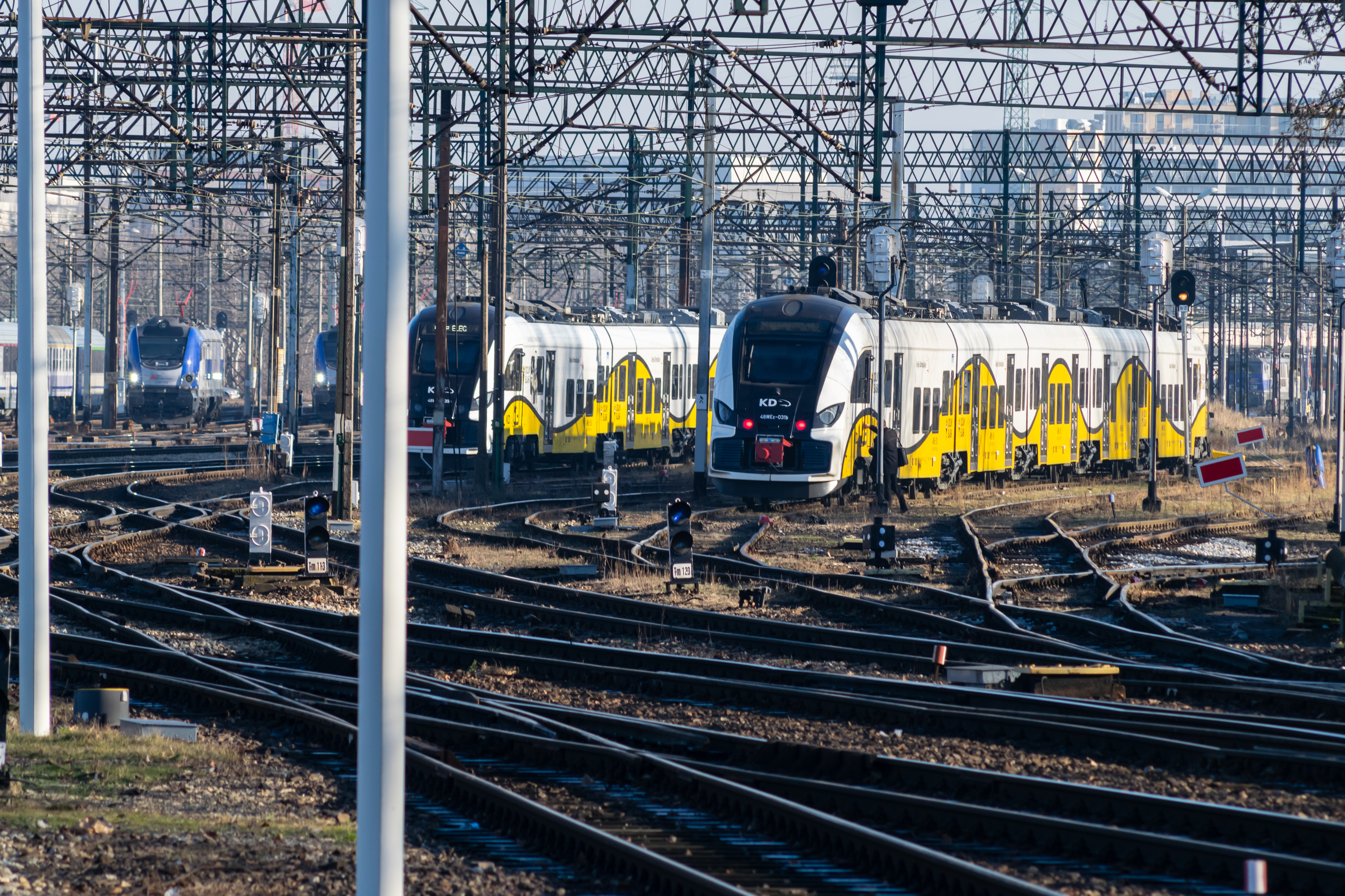 Two yellow-white 48WEc EMUs standing at sidings