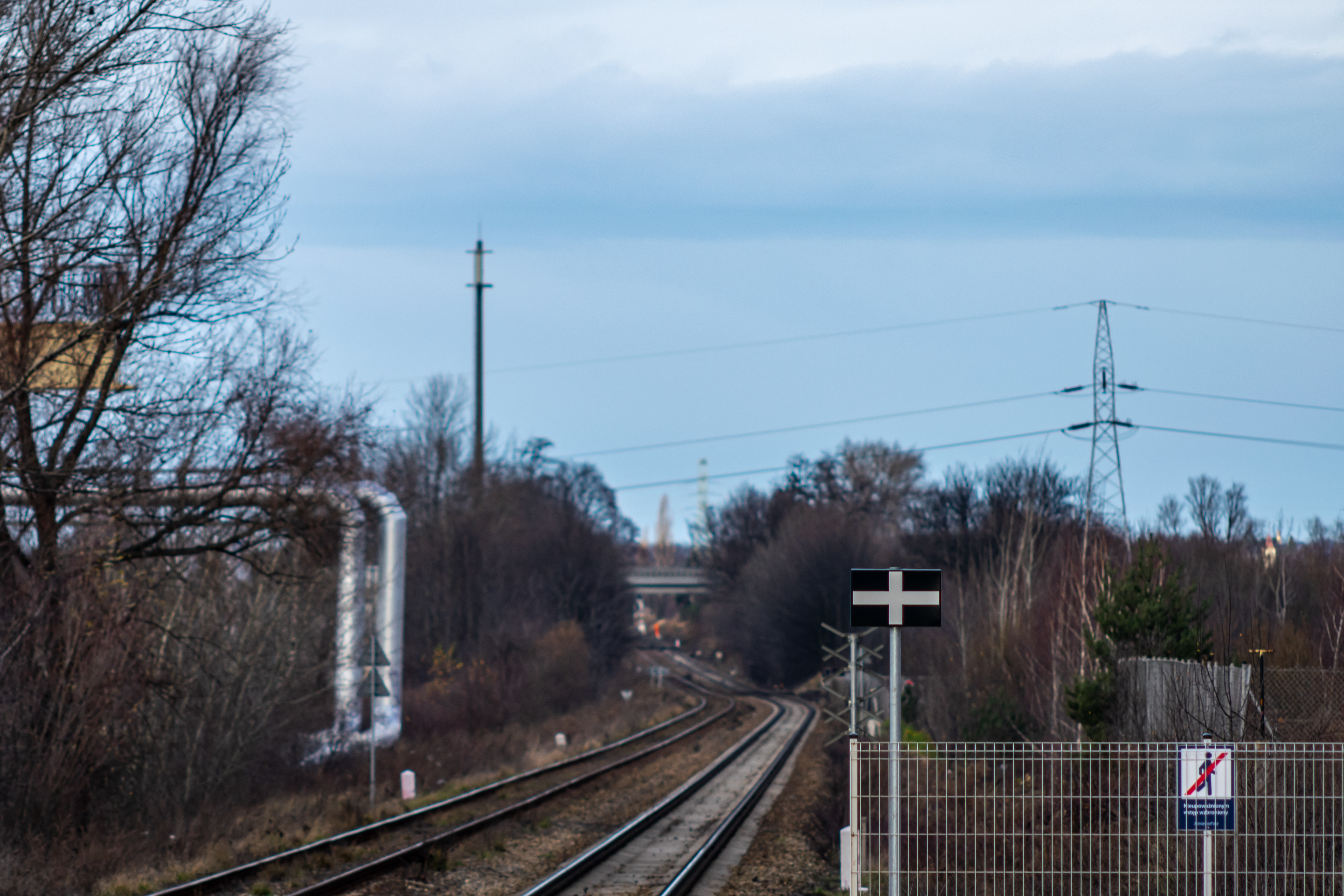train platform stop sign, next to a pair of railway tracks