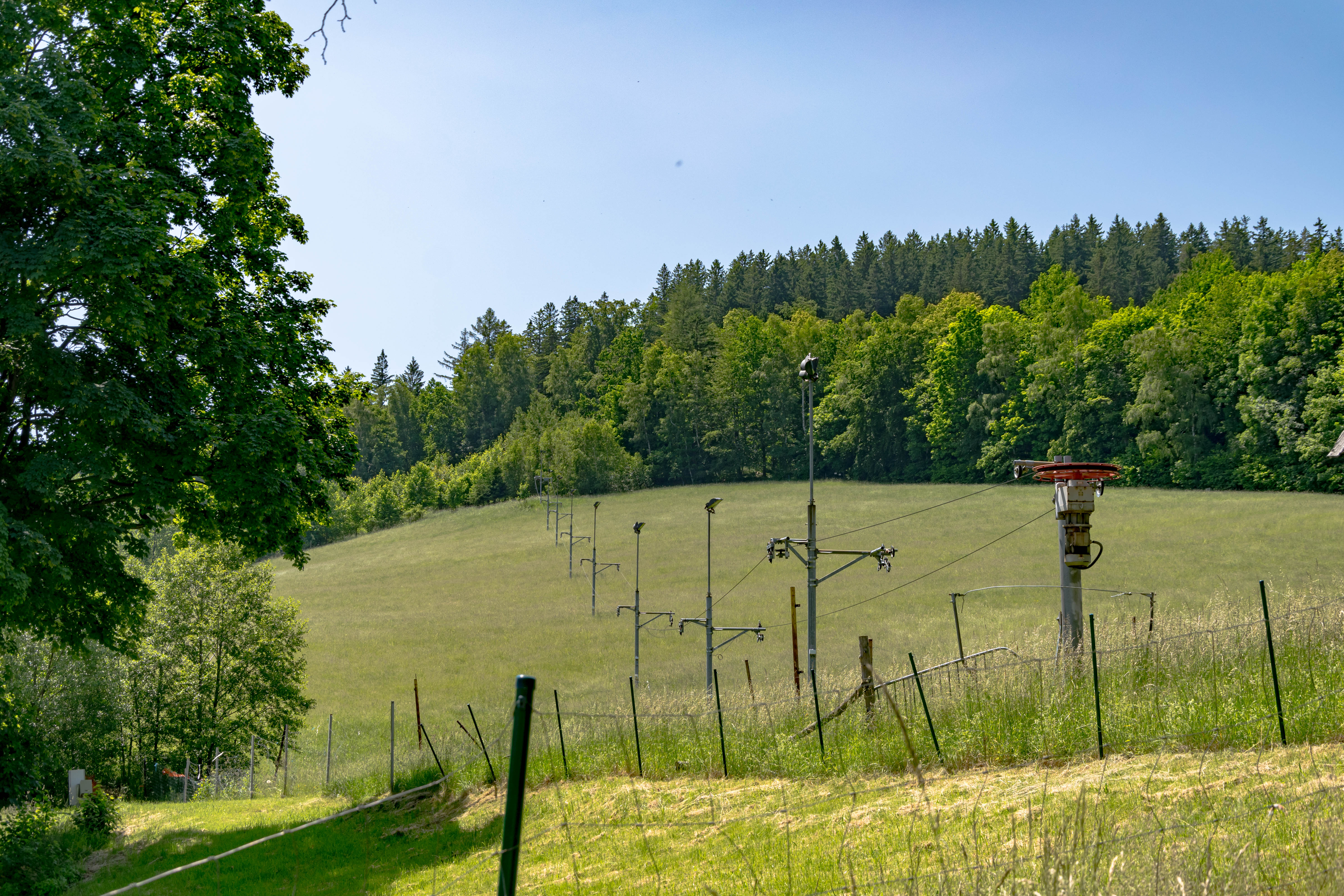 a bunch of gondola poles and lines on a hill, disconnected from anything