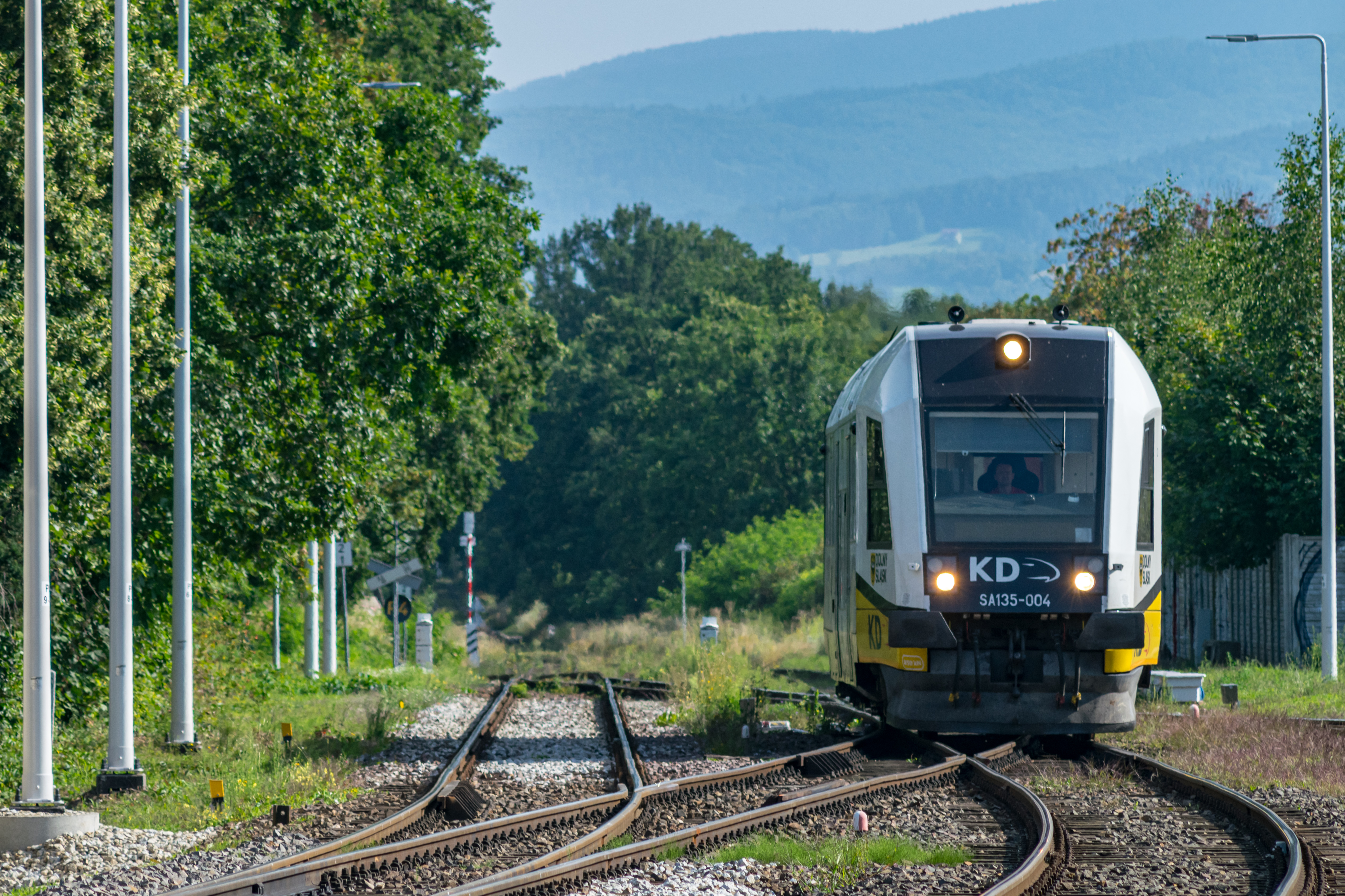 short white-yellow train entering the station
