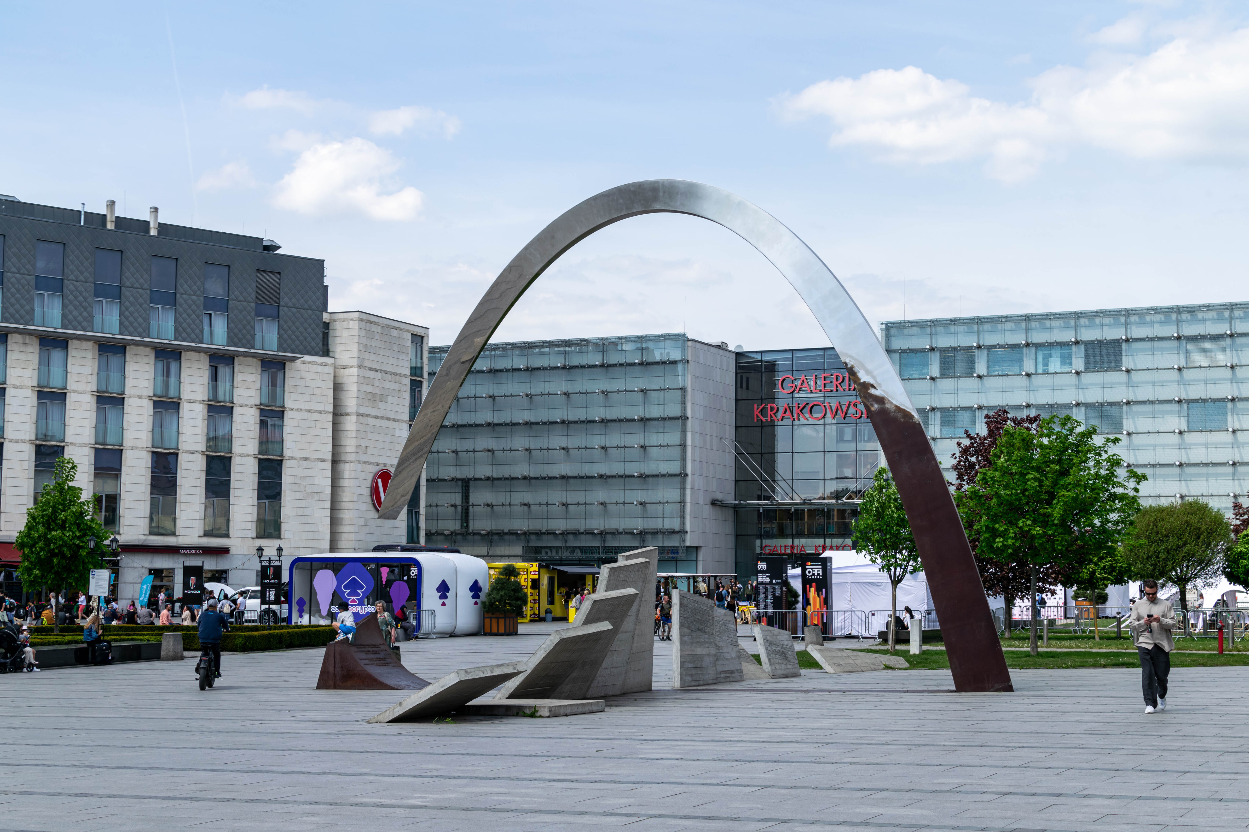 A broken metal arch and sloped plates, opposite to a mall