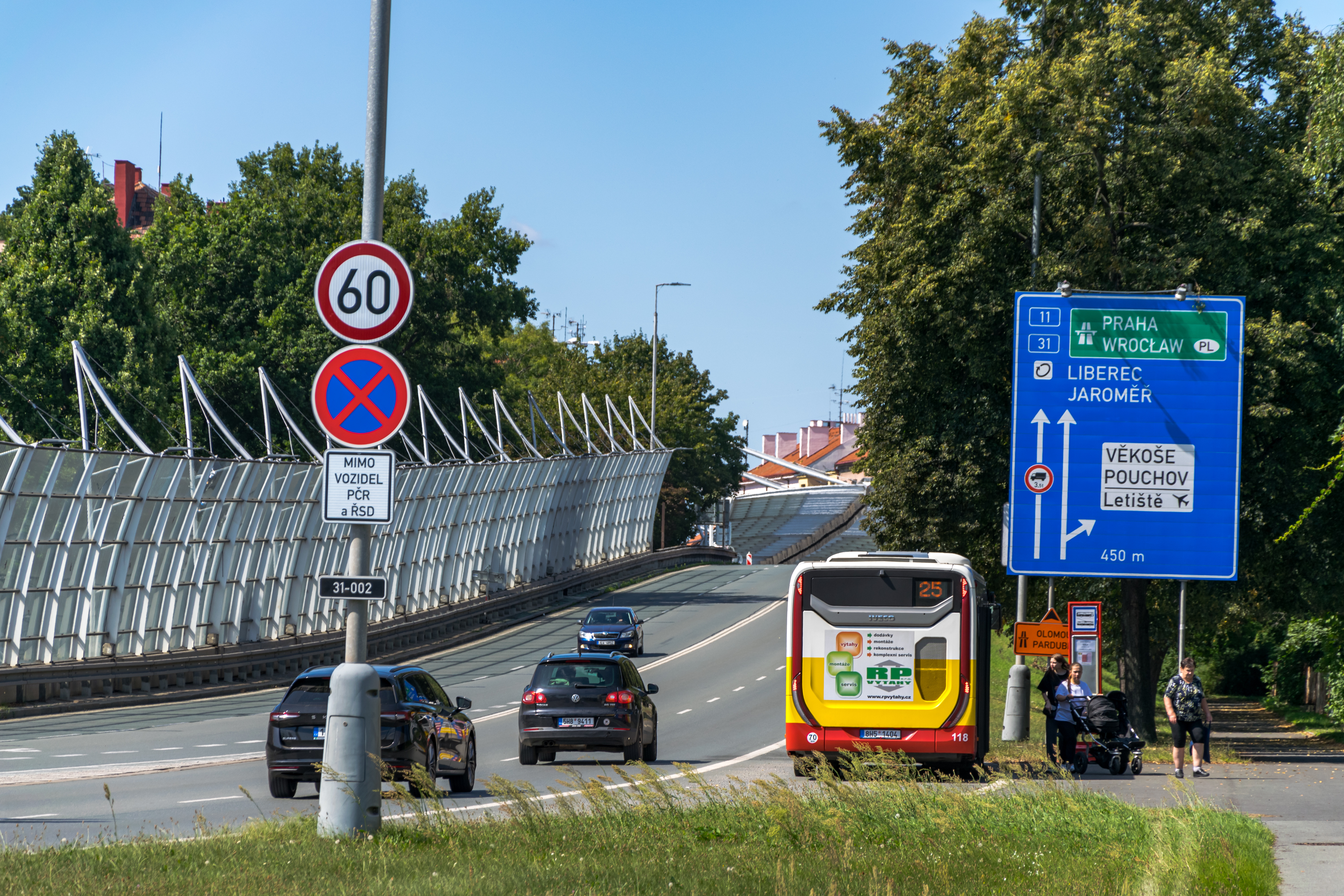 ring road, there's a bus stopped at a bus stop, and lots of sound-proofing panels, like a lot, even a tunnel made of them, Czech specialty